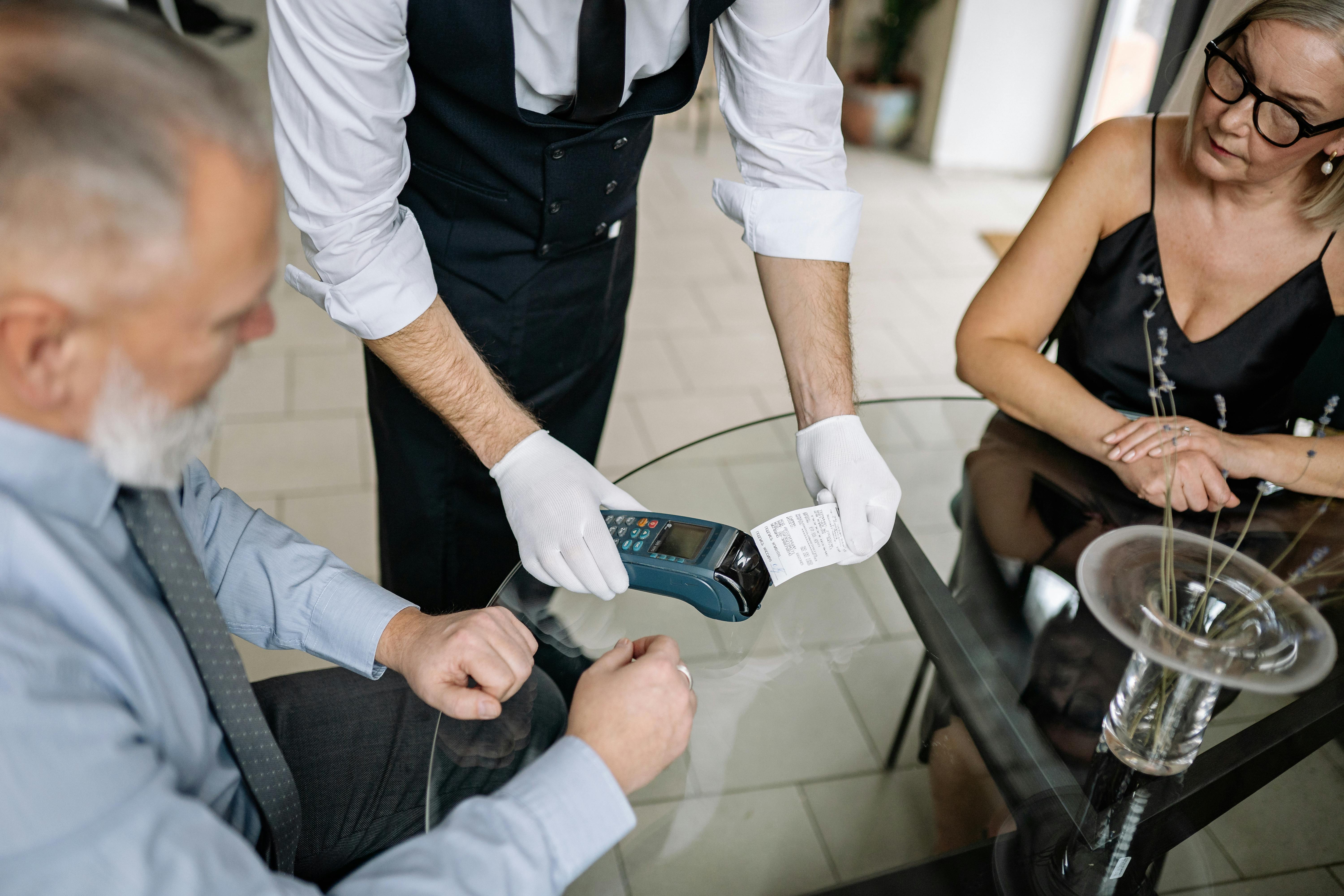 Dos clientes intentando pagar en un restaurante | Fuente: Pexels