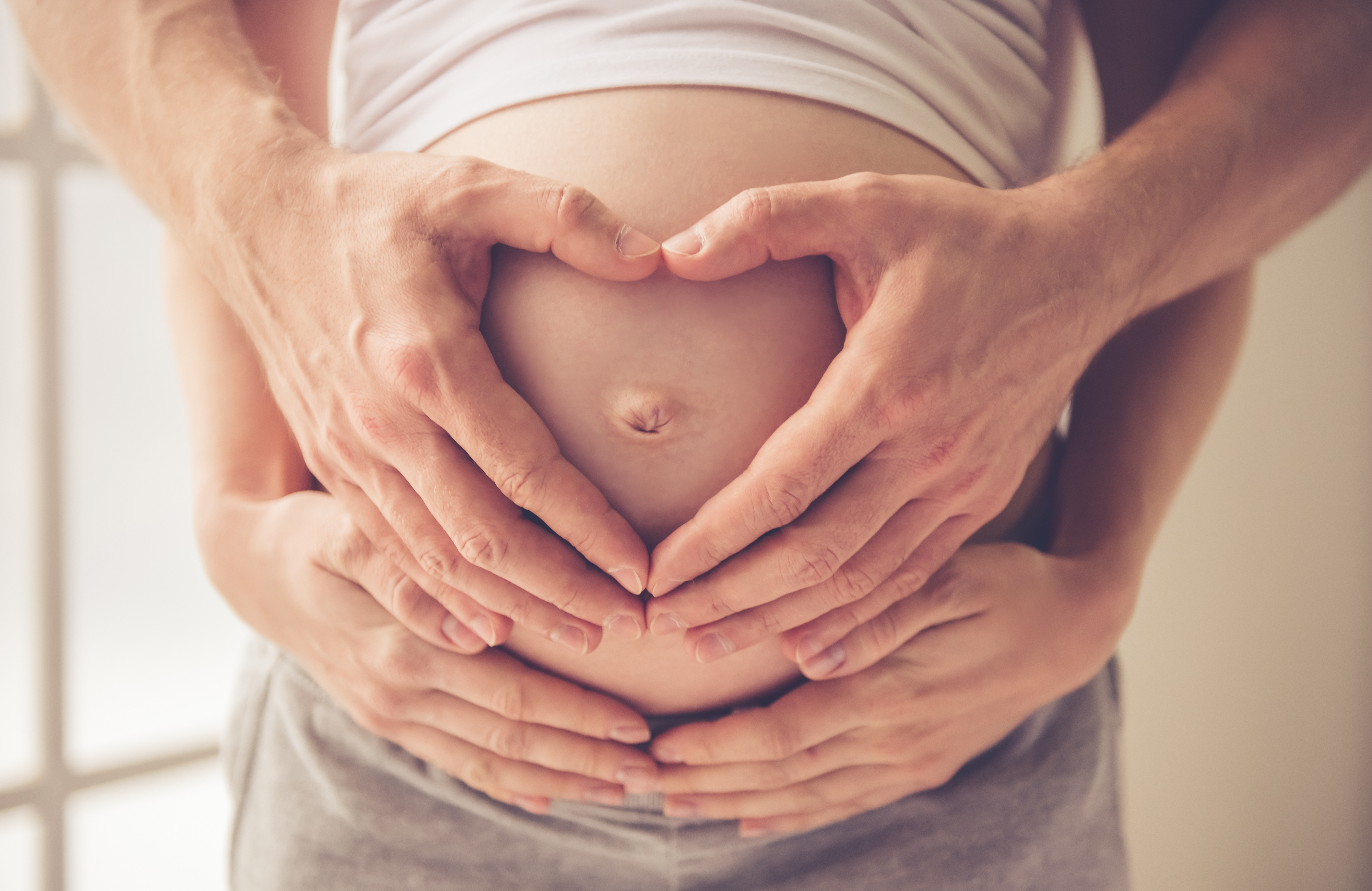 Una pareja sujetando un vientre de embarazada | Foto: Shutterstock