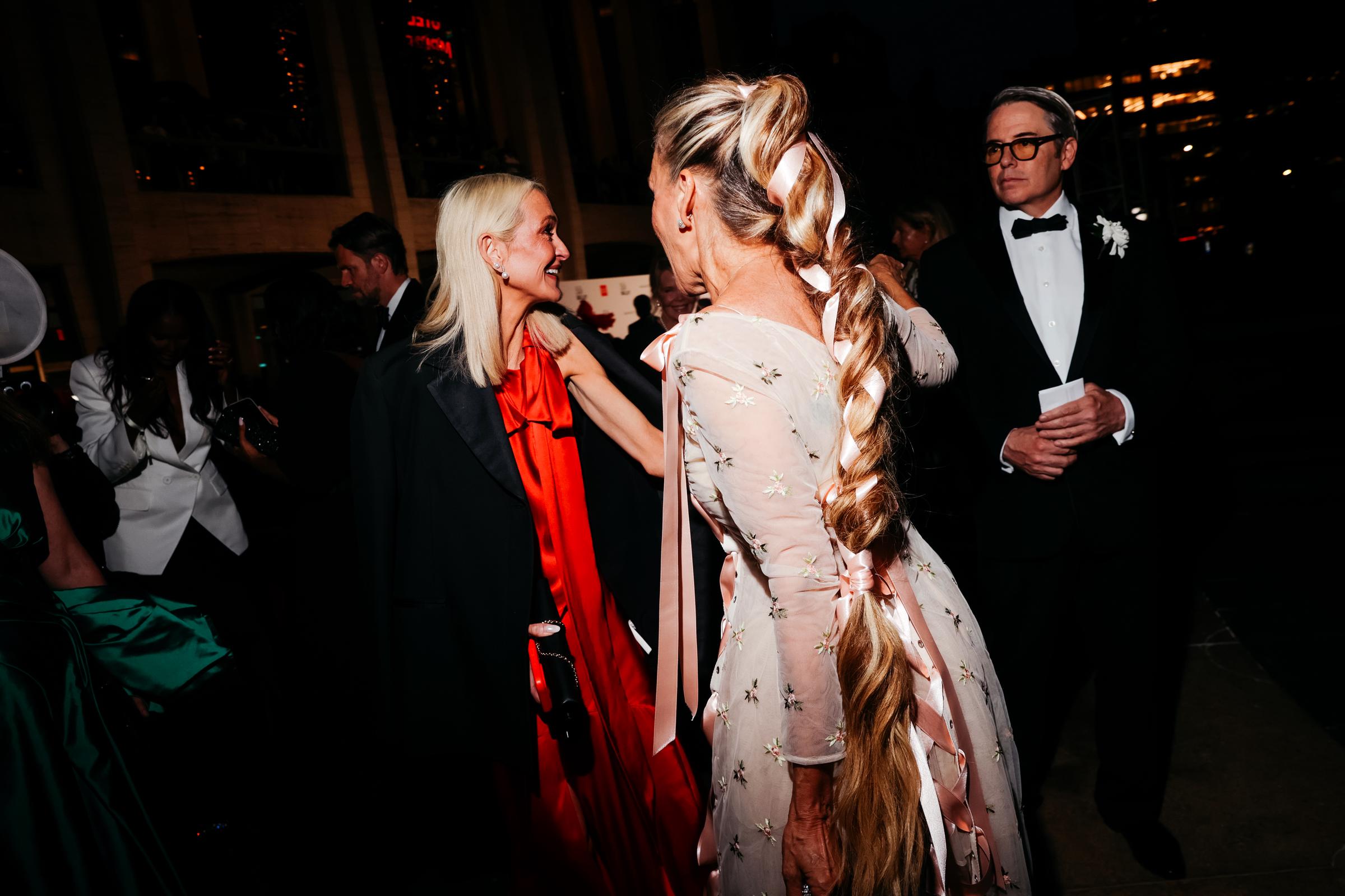 La trenza extralarga de Sarah Jessica Parker acapara toda la atención, con cintas rosas entretejidas en el peinado para combinar con su vestido bordado con motivos florales. Matthew Broderick está a su lado con un esmoquin negro clásico. | Fuente: Getty Images