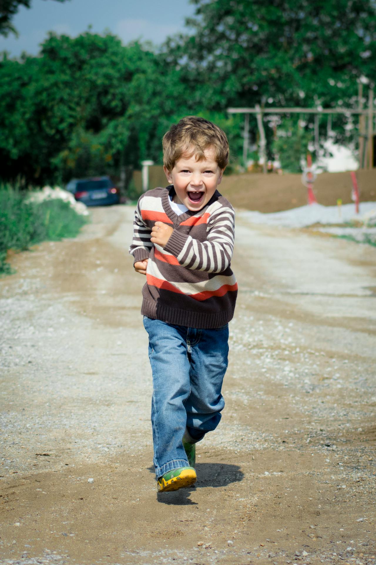 Un niño feliz caminando por la carretera | Fuente: Pexels