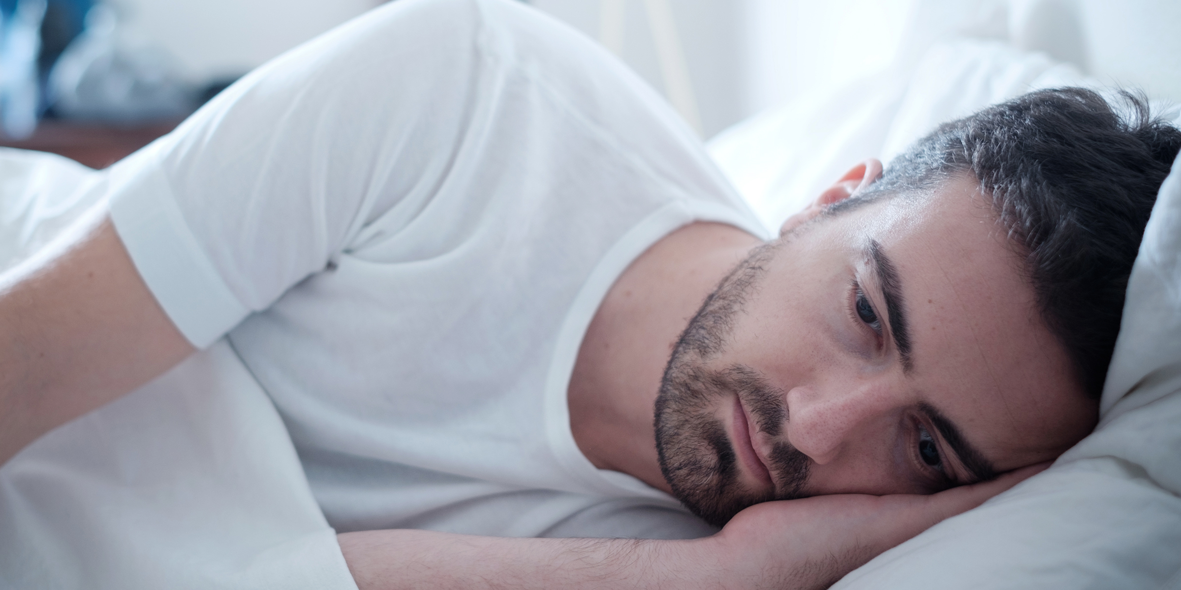 Un hombre tumbado en la cama | Fuente: Shutterstock