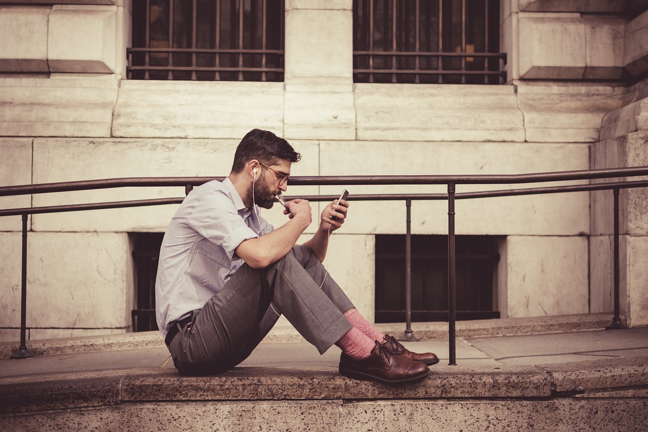 Un hombre sentado en el suelo hablando por teléfono | Fuente: Pixabay