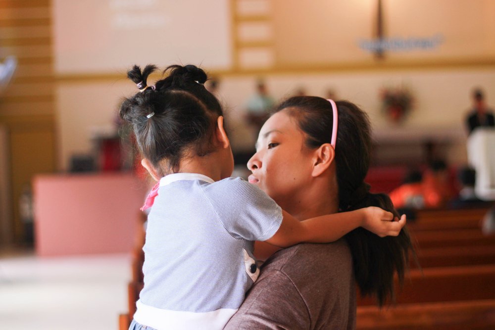 Mujer viendo a su hija, a quien toma entre brazos. | Foto: Shutterstock