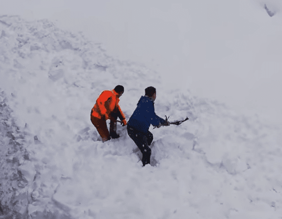 Dos hombres remueven la nieve | Foto: YouTube/unsereOEBB