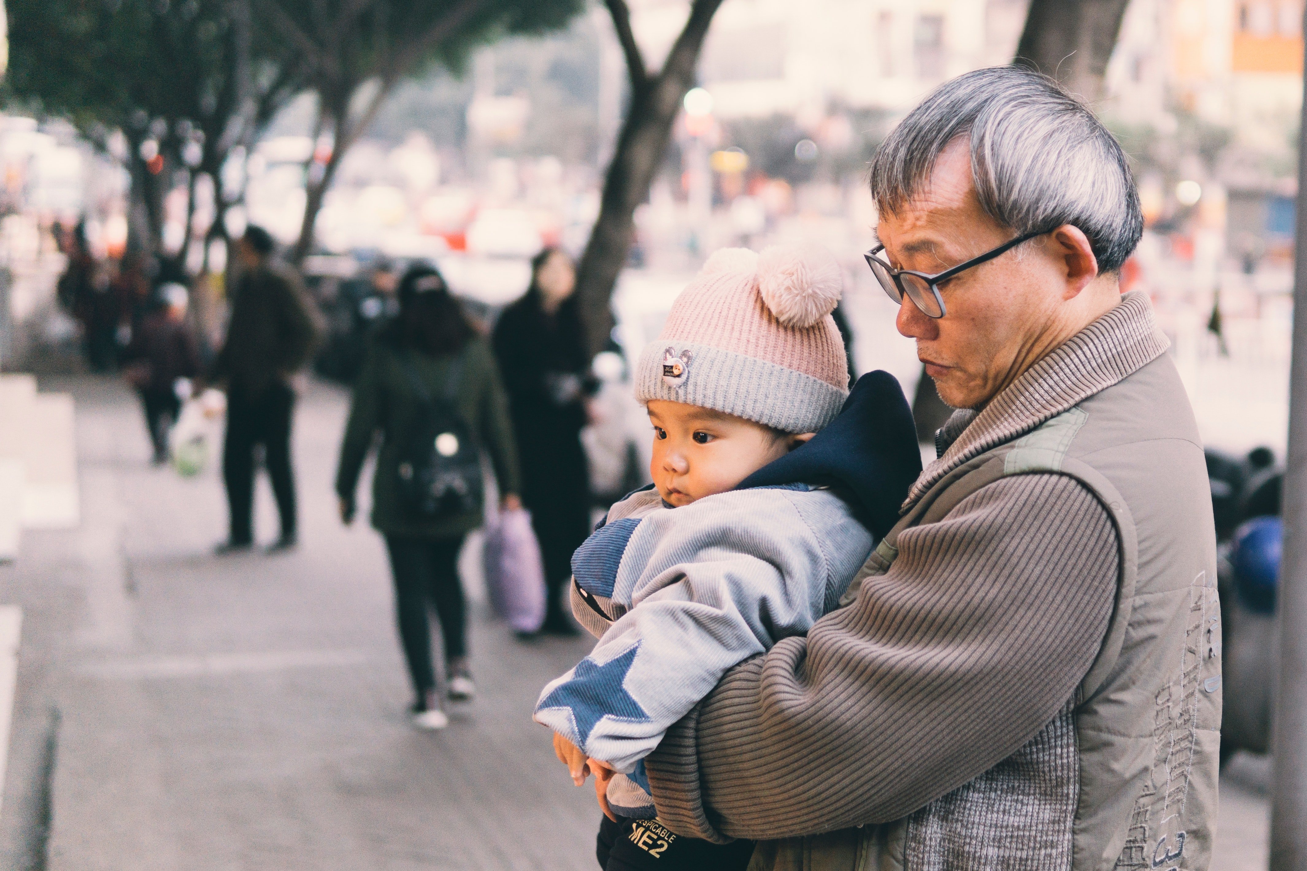 Anciano sosteniendo a un niño. | Foto: Pexels