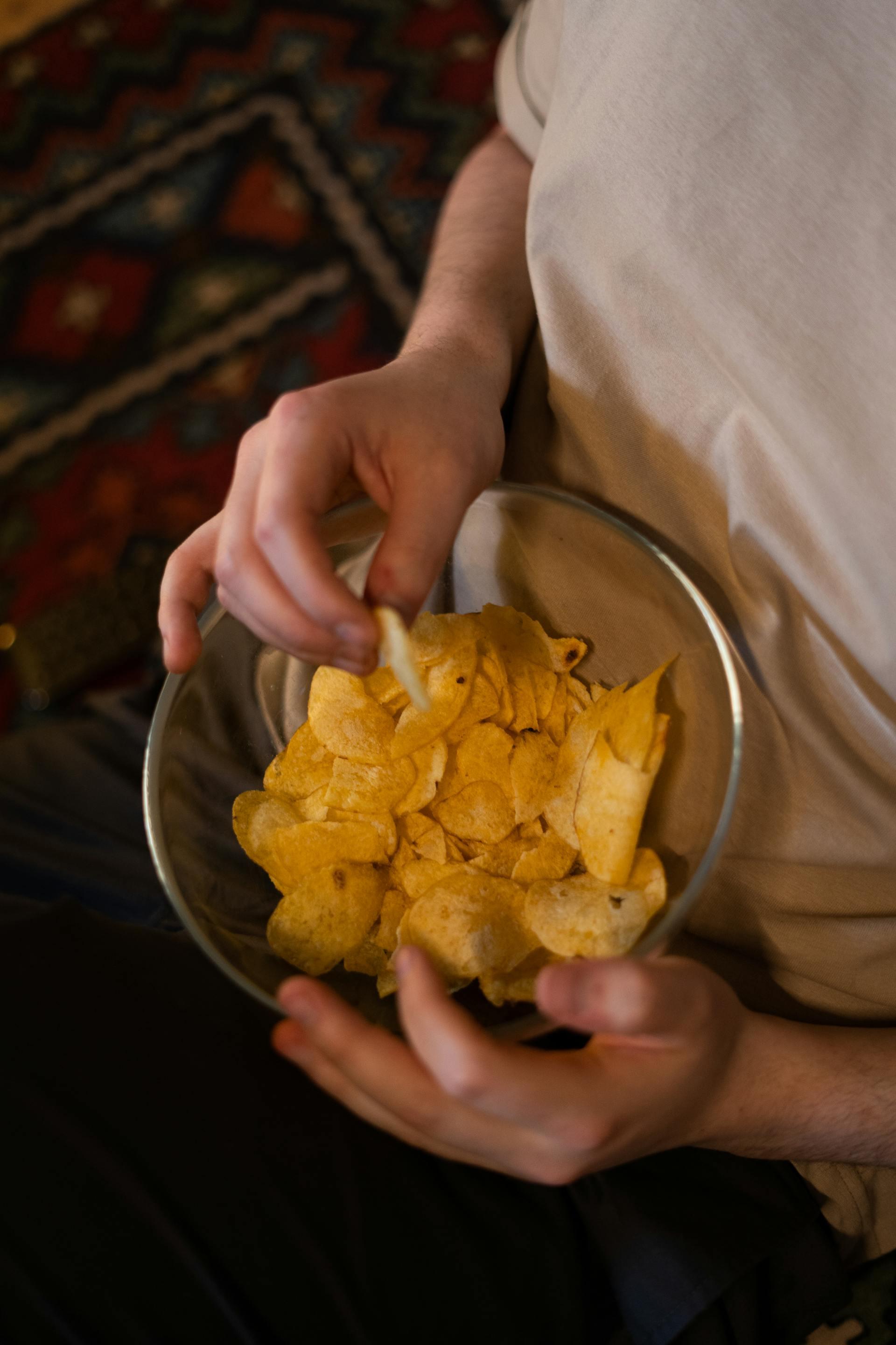 Una persona con un cuenco de patatas fritas | Fuente: Pexels