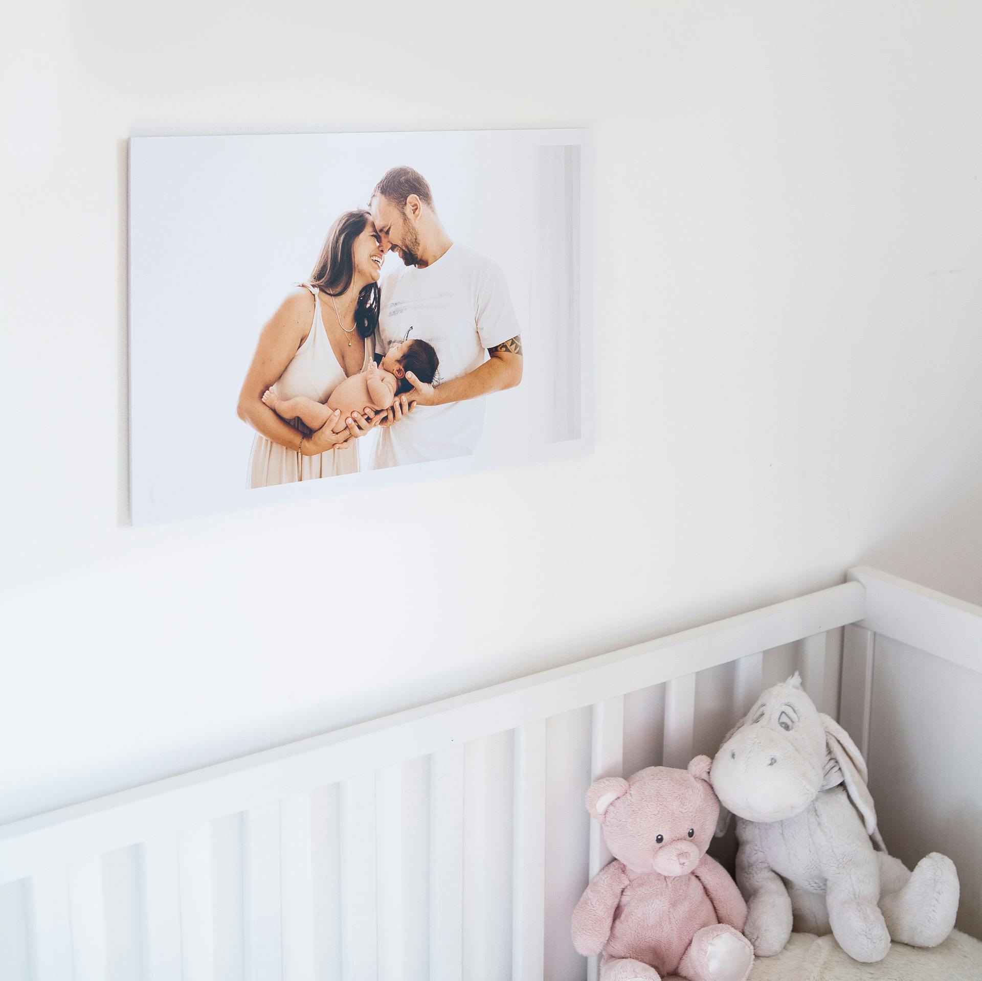 Una foto de una pareja con su bebé recién nacido colgada en una habitación | Foto: Pexels