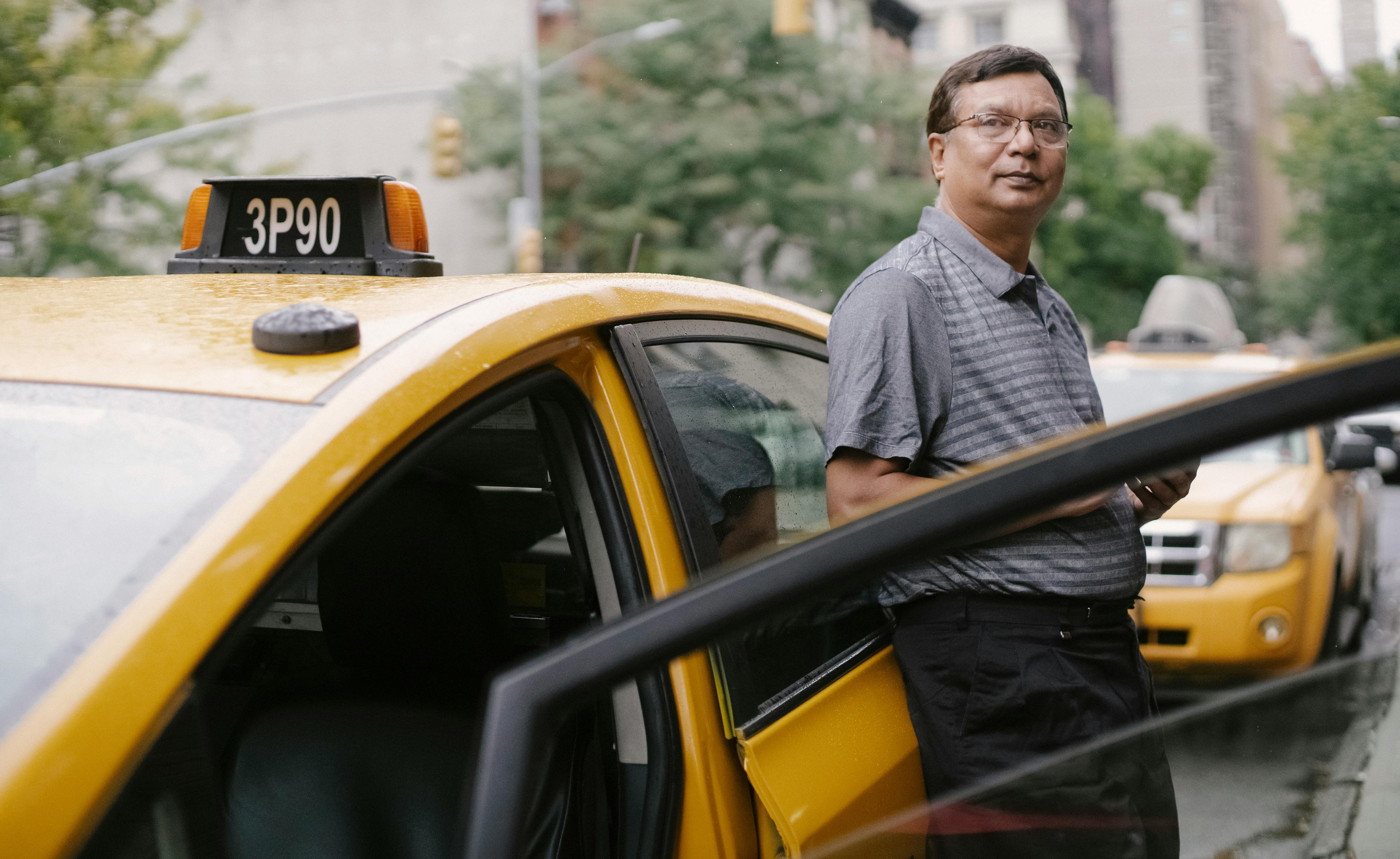 Un hombre de pie junto al taxi | Fuente: Pexels