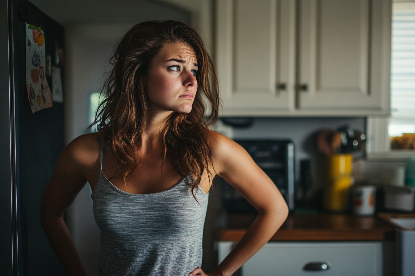 Una mujer preocupada en una cocina | Fuente: Midjourney