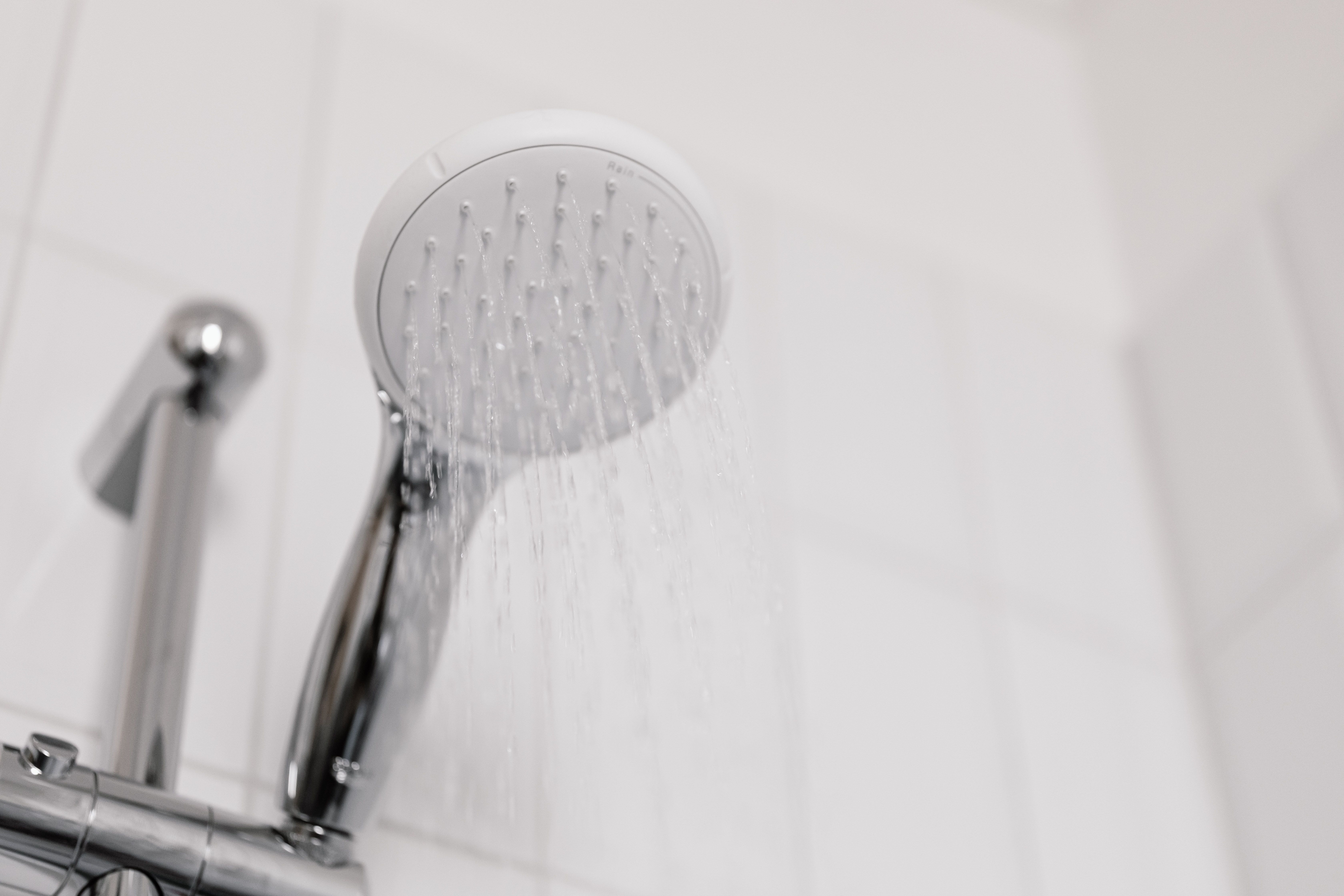 Agua corriendo en un baño con azulejos blancos | Fuente: Pexels