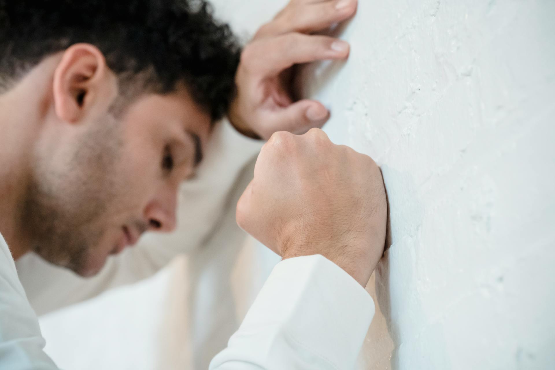 Un hombre deprimido apoyando la cabeza en la pared | Fuente: Pexels