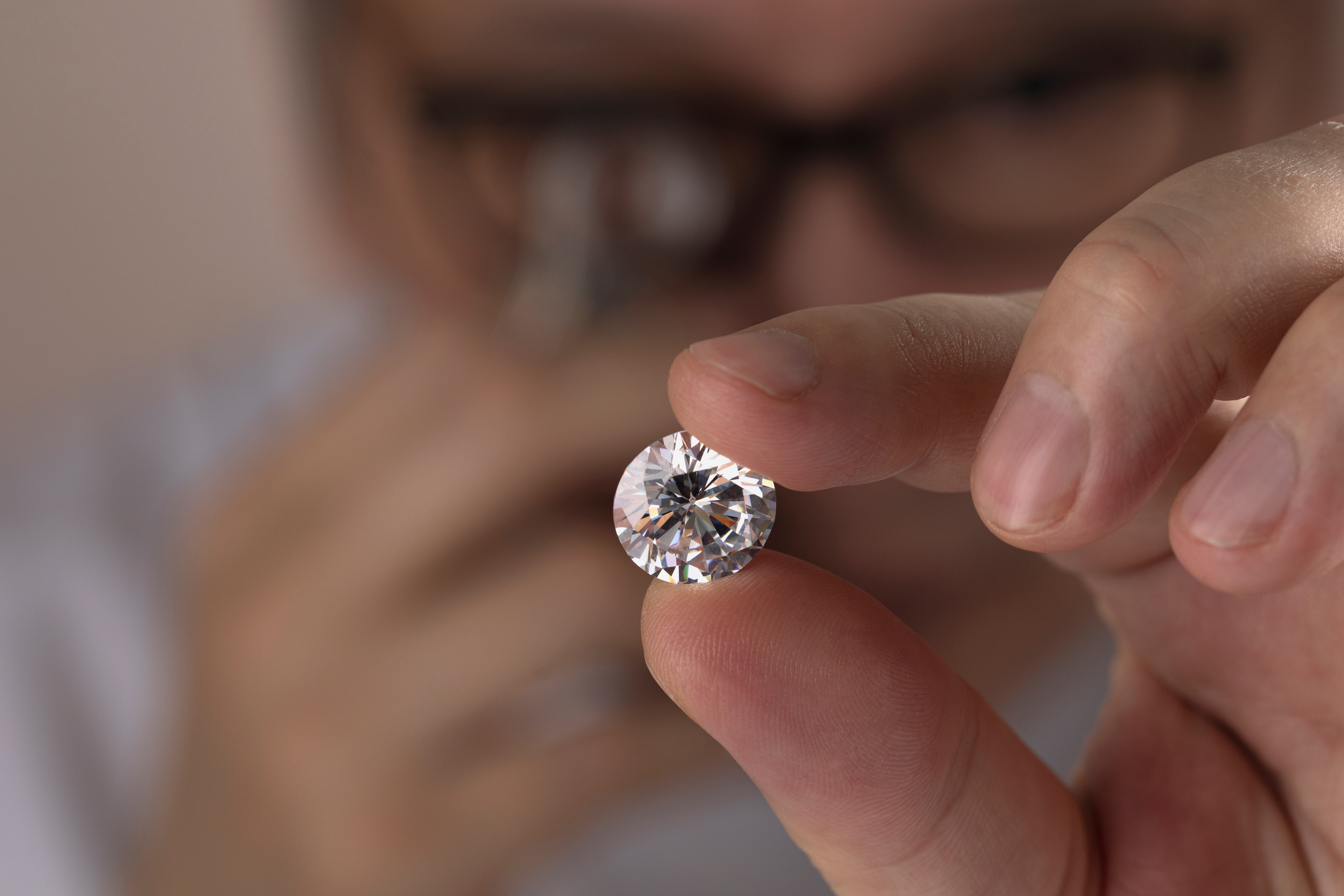 Hombre con gafas mira un diamante | Fuente: Shutterstock.com