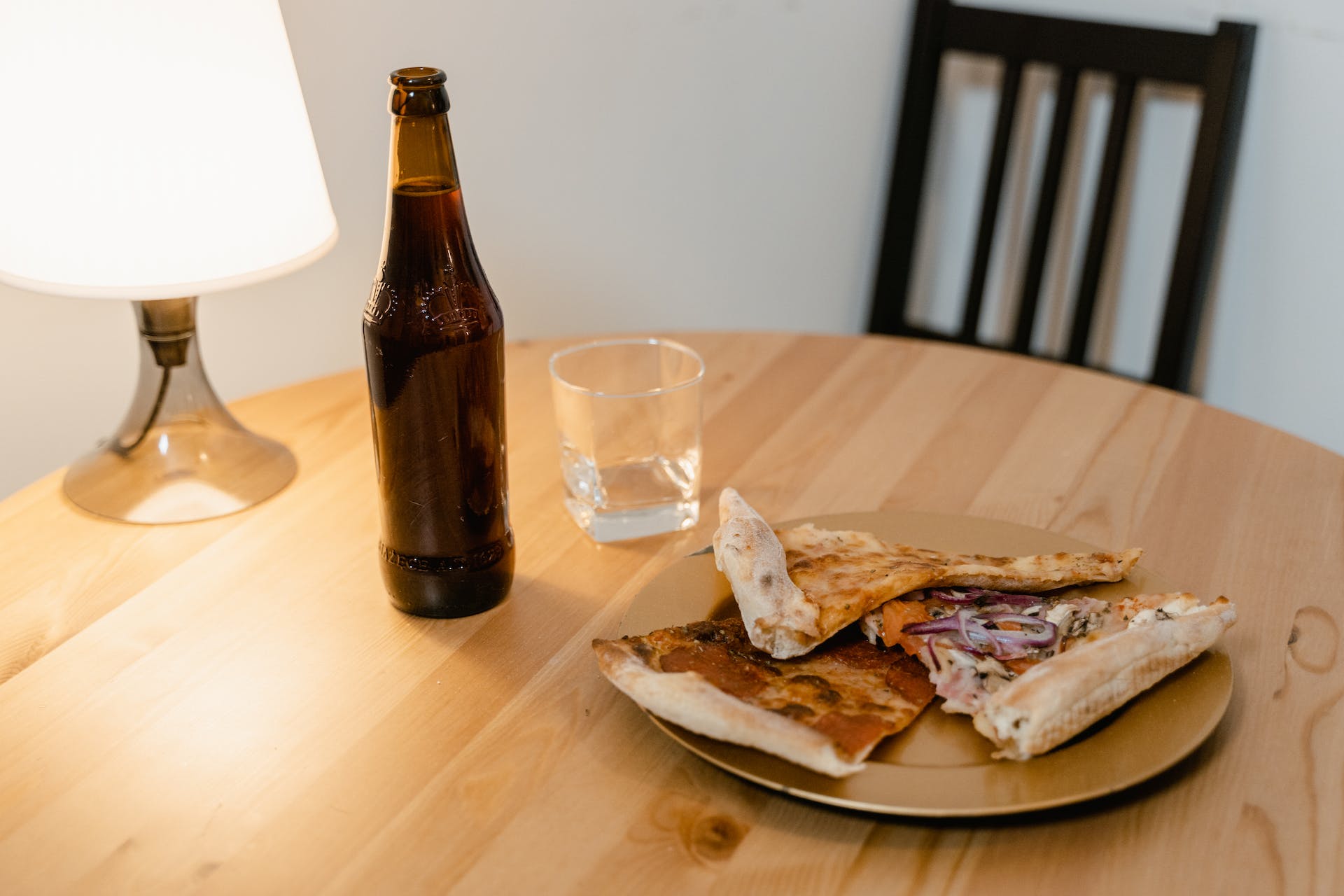 Pizza y cerveza sobre la mesa | Foto: Pexels