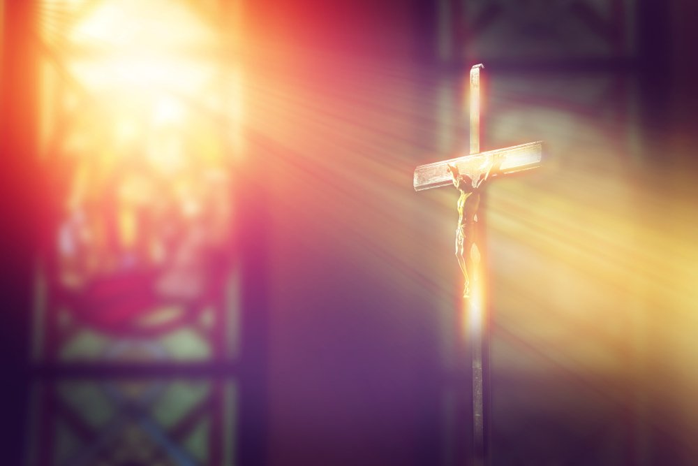Luz del vitral cayendo sobre la cruz.| Fuente: Shutterstock