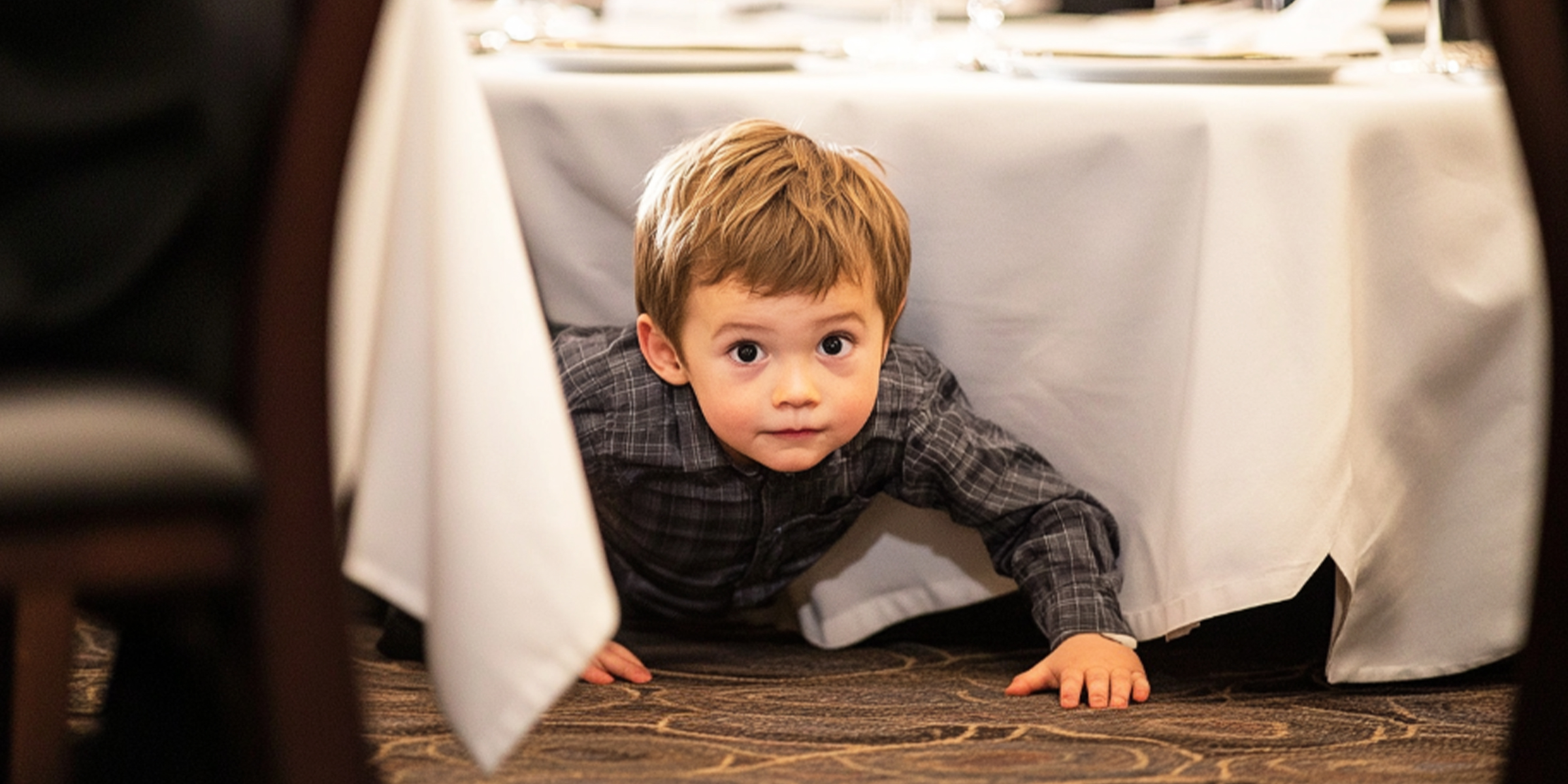 Un niño gateando por debajo de una mesa | Fuente: The Celebritist