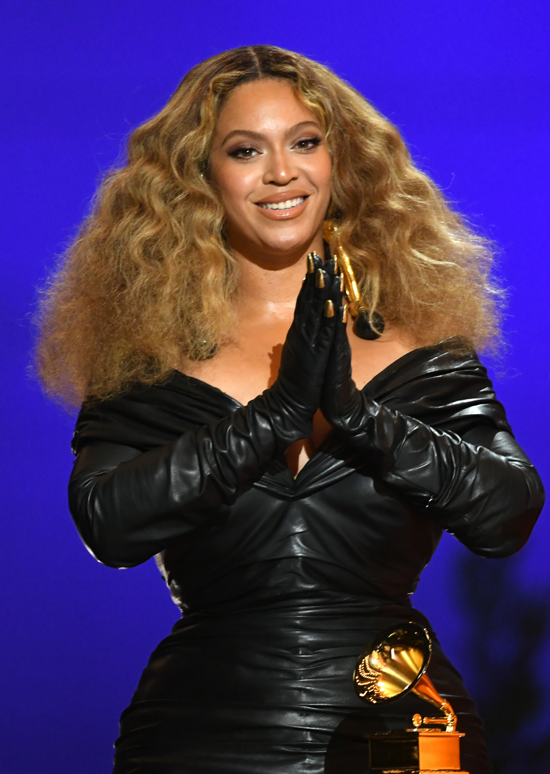 Beyoncé sonríe con un conjunto negro y una melena rubia ondulada en los Premios Grammy 2021, celebrados en Los Ángeles. La última portada de la cantante en la revista i-D marca su regreso a la publicación tras 20 años, esta vez en colaboración con su marca de productos para el cuidado del cabello, Cécred. | Fuente: Getty Images
