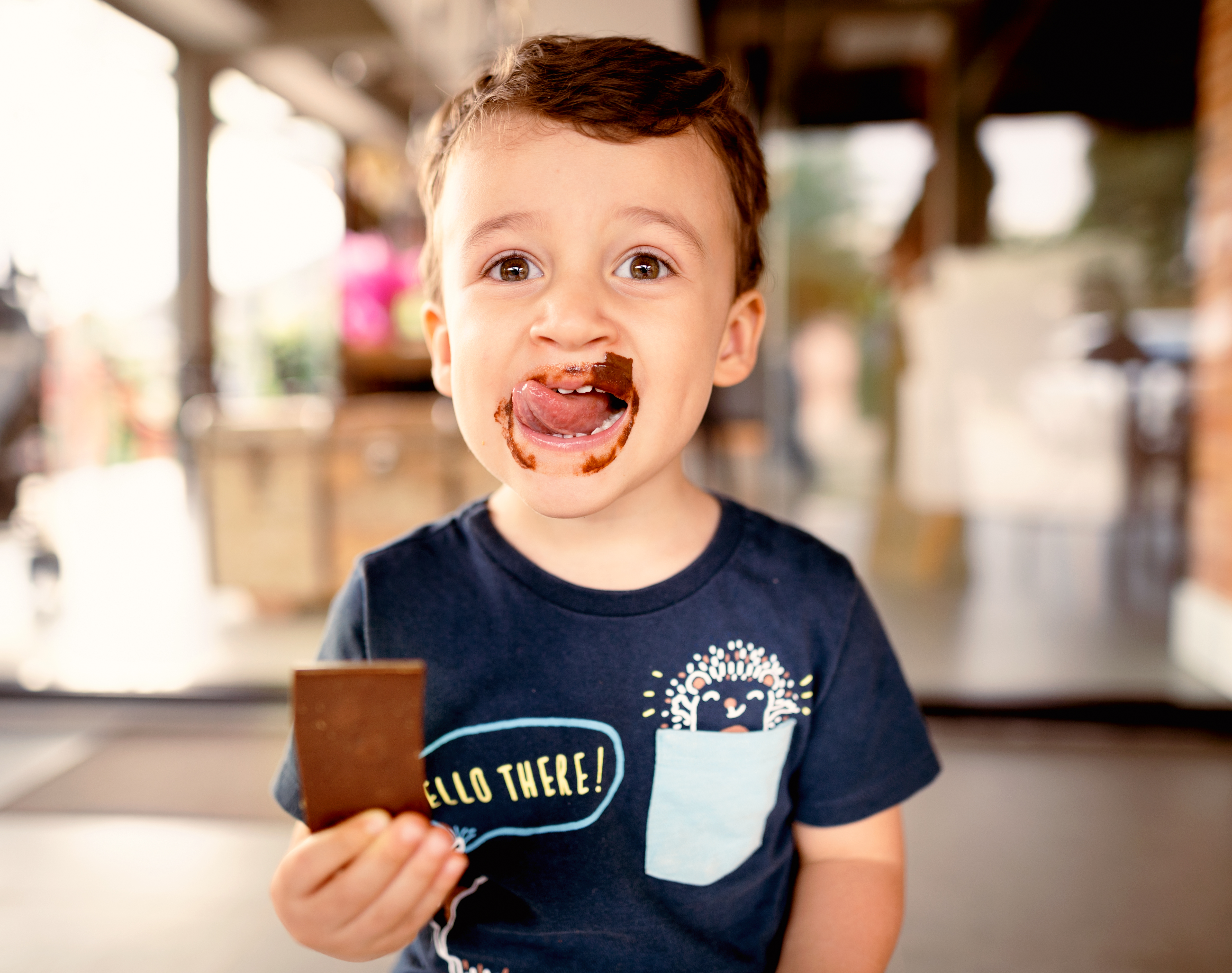 Niño sonriente lamiendo chocolate sucio de su cara | Fuente: Getty Images