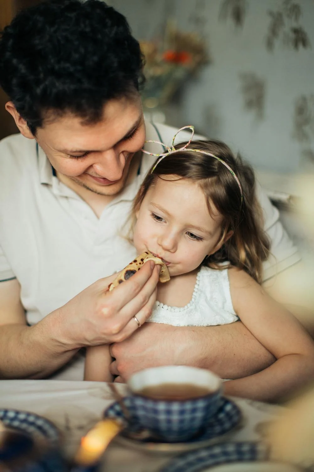 Un hombre dando de comer a su hija | Fuente: Pexels