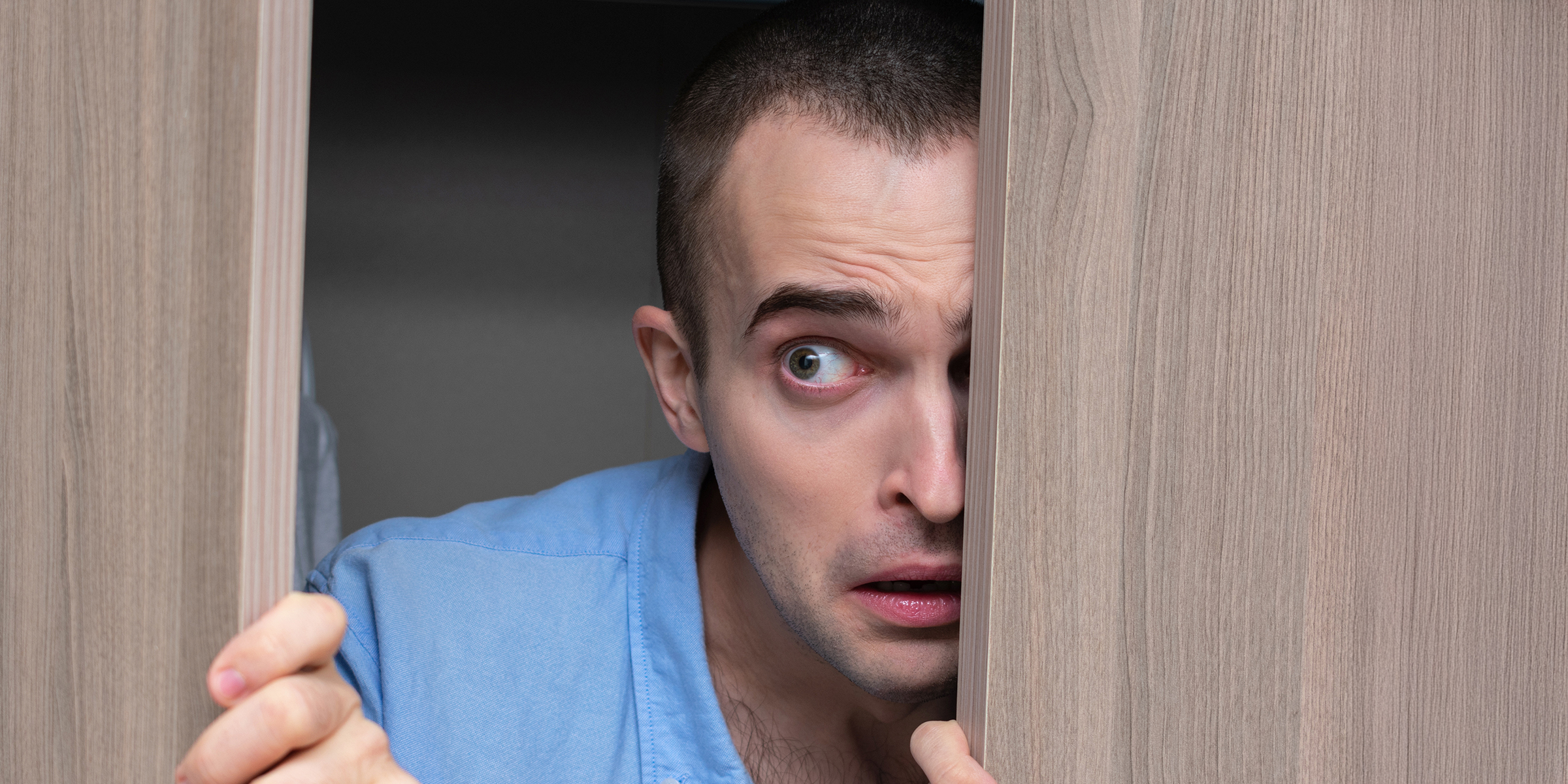 Un hombre asomándose por una puerta | Fuente: Shutterstock