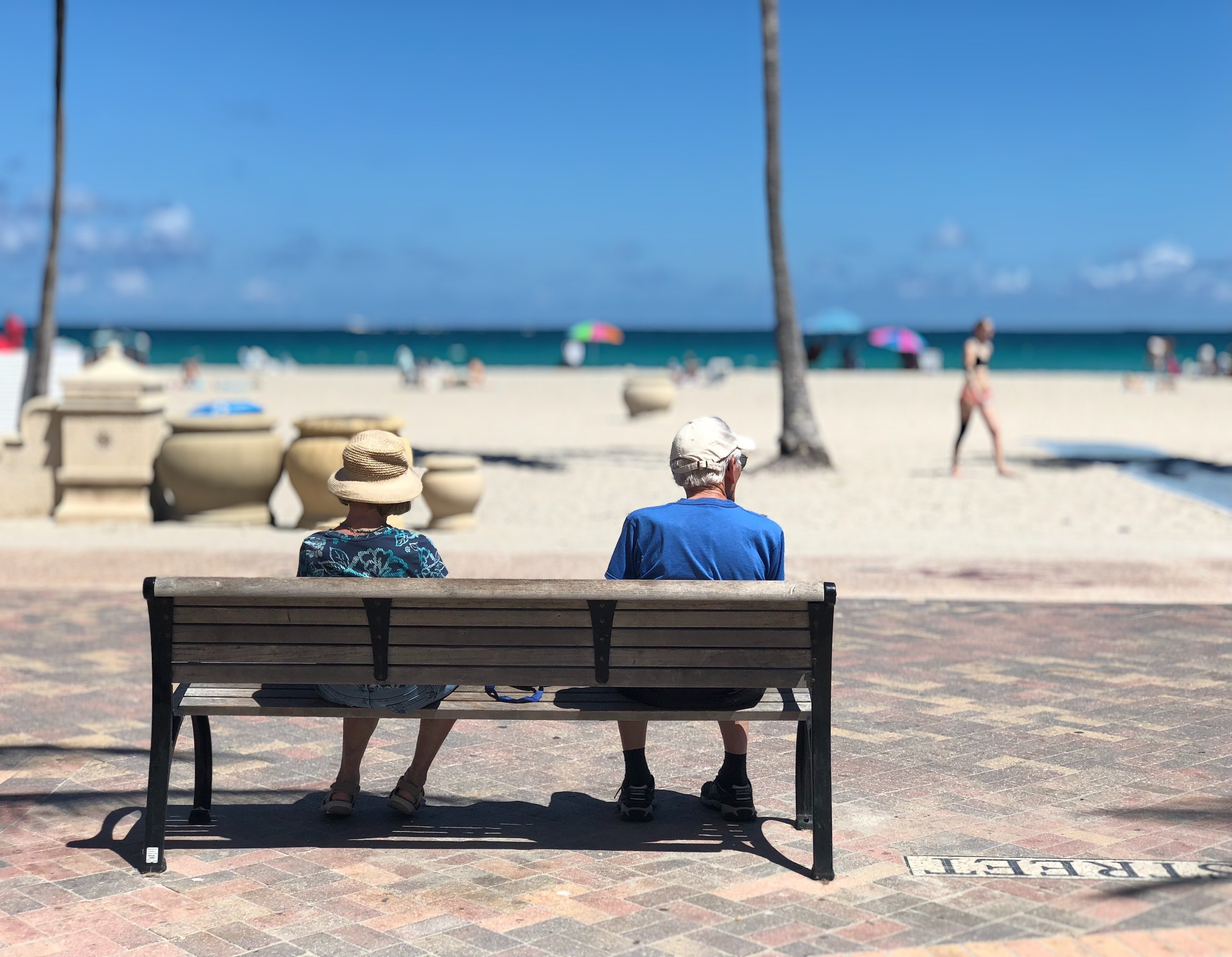 Pareja sentada en un banco en la playa. | Foto: Pexels