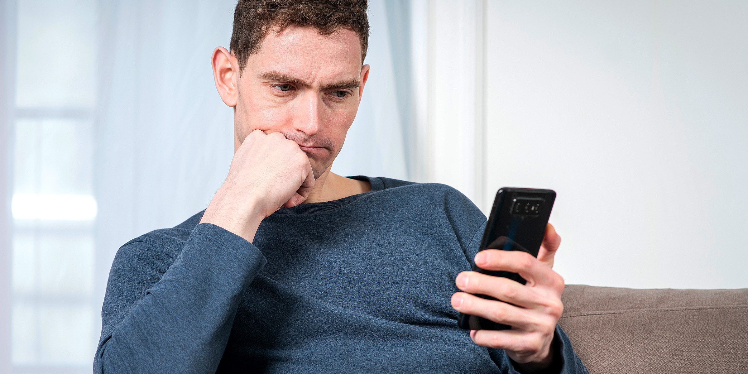 Un hombre con un teléfono en la mano | Fuente: Shutterstock