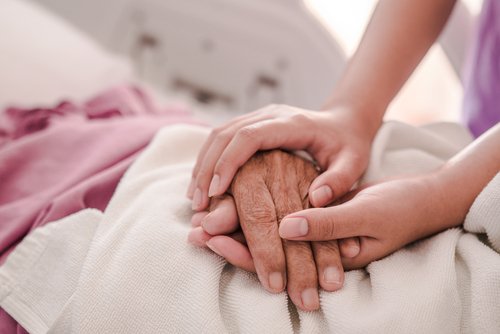 Enfermera tomando la mano de una abuela en la cama del hospital. | Foto: Shutterstock