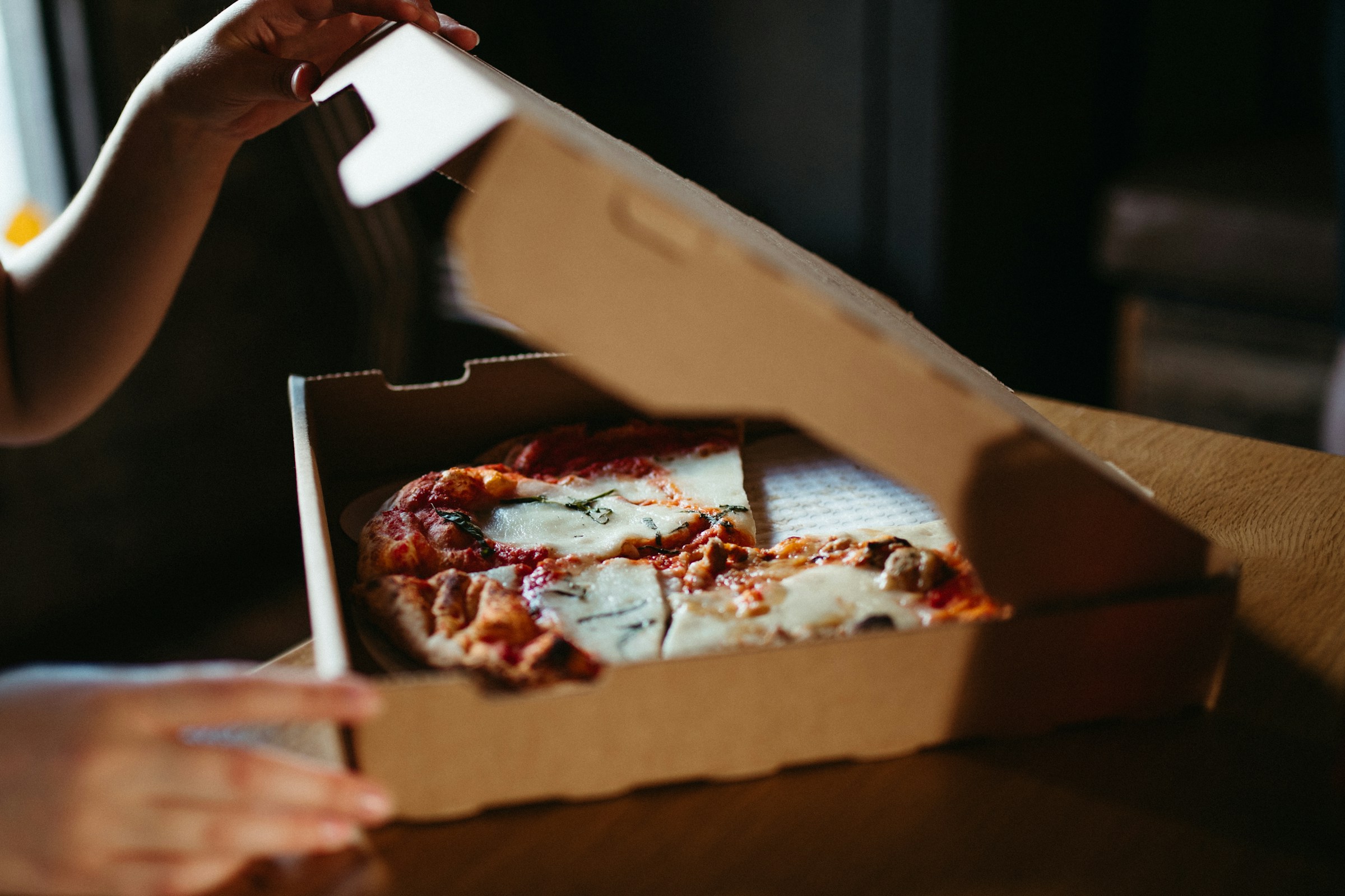 Una persona abriendo una caja de pizza | Fuente: Pexels