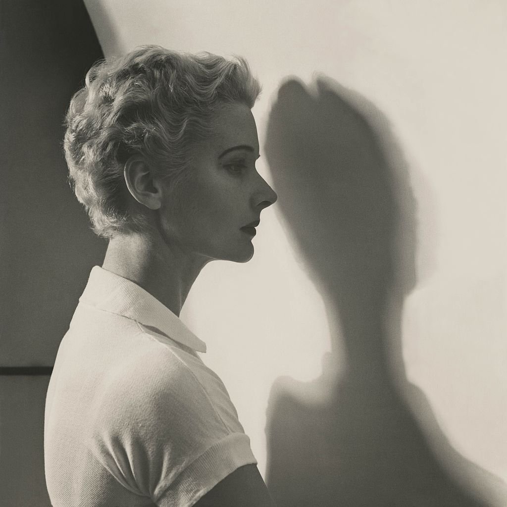 C. Z. Guest de perfil, con su sombra reflejada en una pared y su pelo peinado con ondas cortas. | Foto: Getty Images