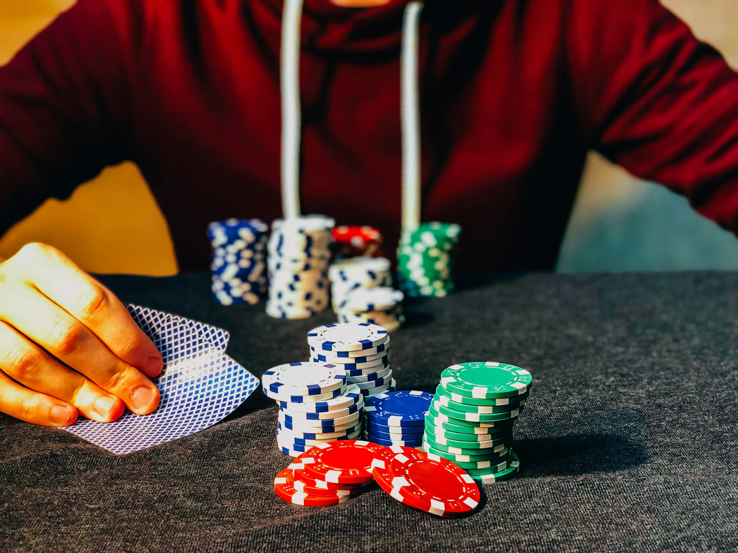 Un hombre en un casino, sentado con fichas de póquer | Fuente: Unsplash