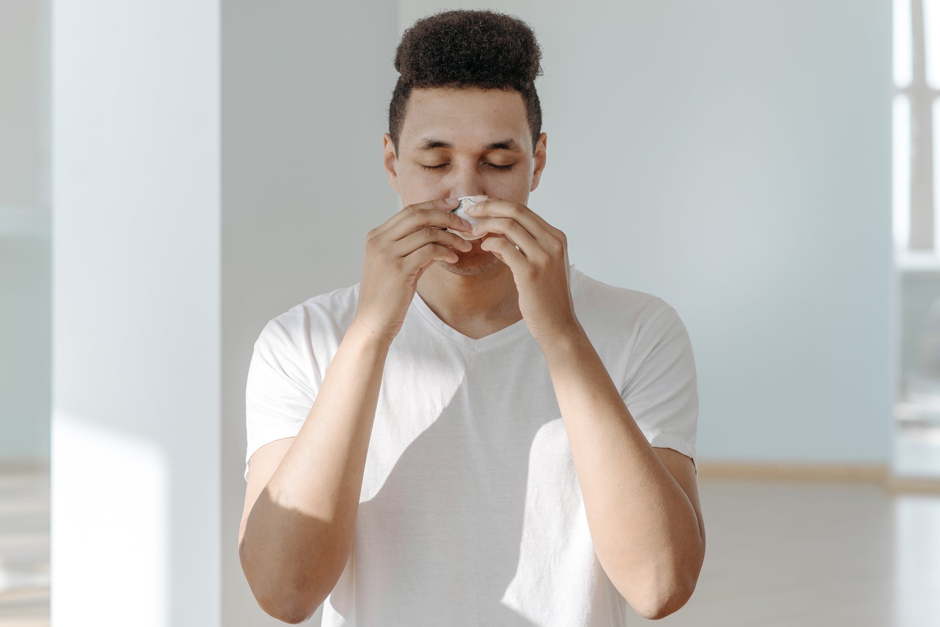 Hombre limpiándose la nariz | Fuente: Pexels