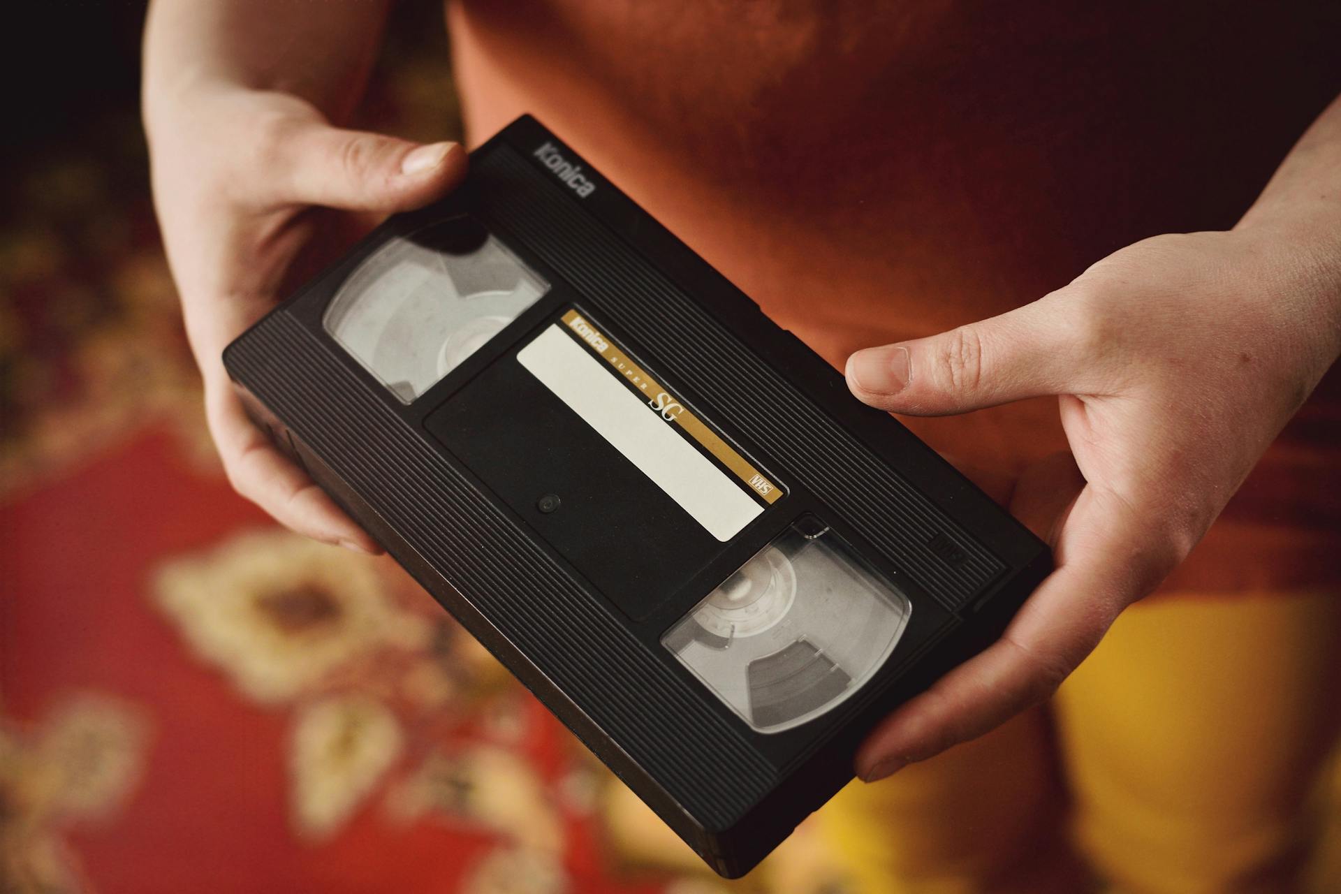 Primer plano de una persona sujetando una cinta VHS | Fuente: Pexels