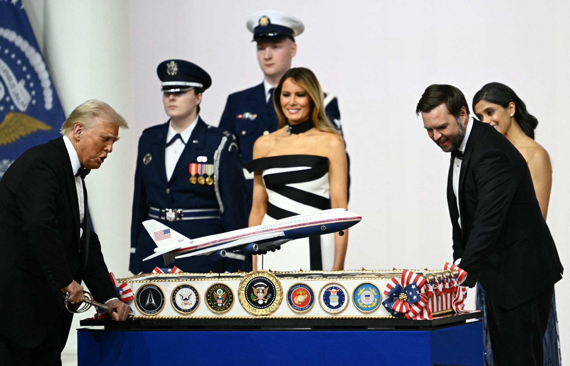 La Primera Dama Melania Trump junto a Usha Vance observan cómo el Presidente de EE.UU. Donald Trump y el Vicepresidente J.D. Vance cortan un pastel que representa el nuevo diseño del Air Force One con un sable, durante el baile inaugural del Comandante en Jefe, el 20 de enero de 2025 | Fuente: Getty Images