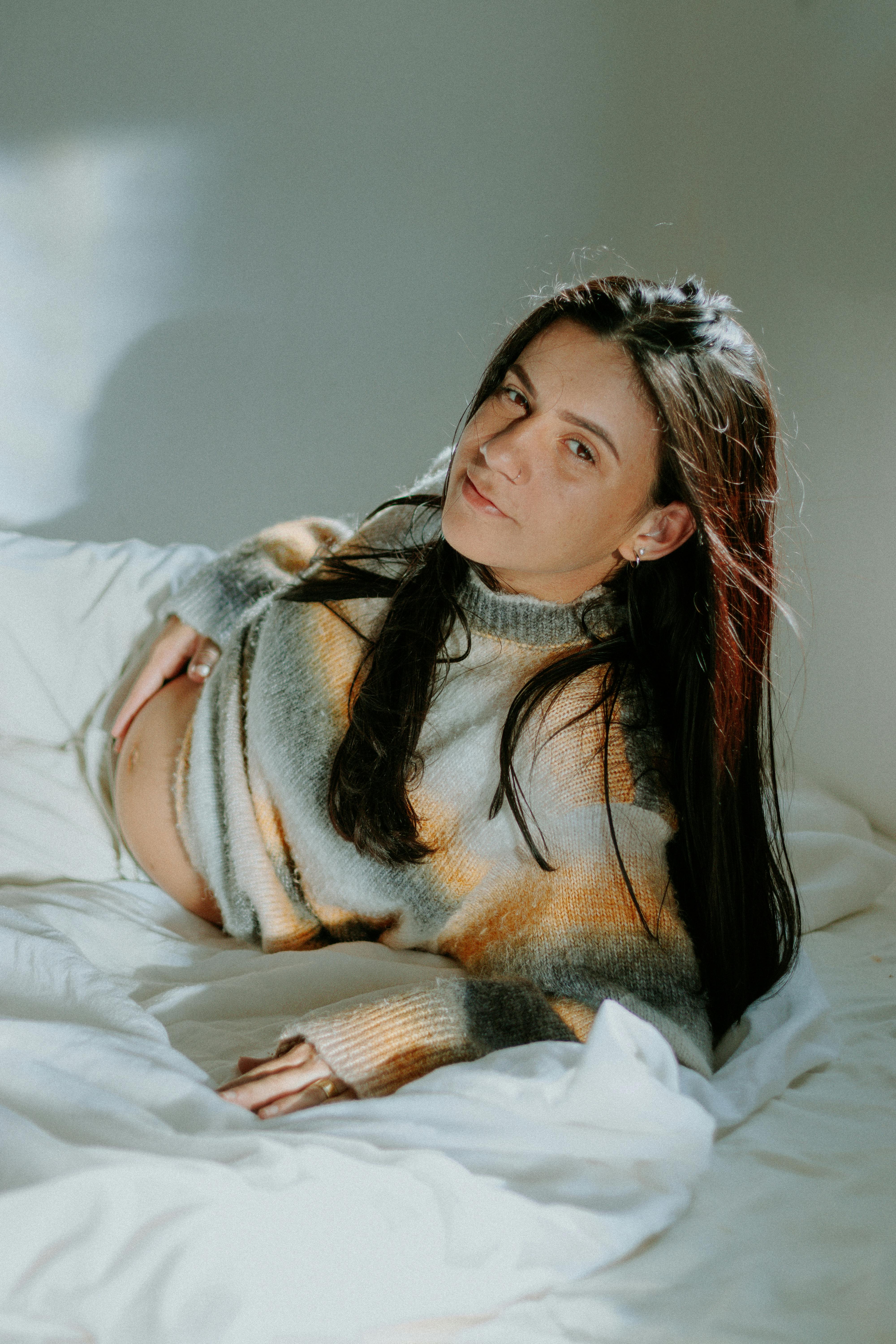 Mujer embarazada en una cama | Foto: Pexels
