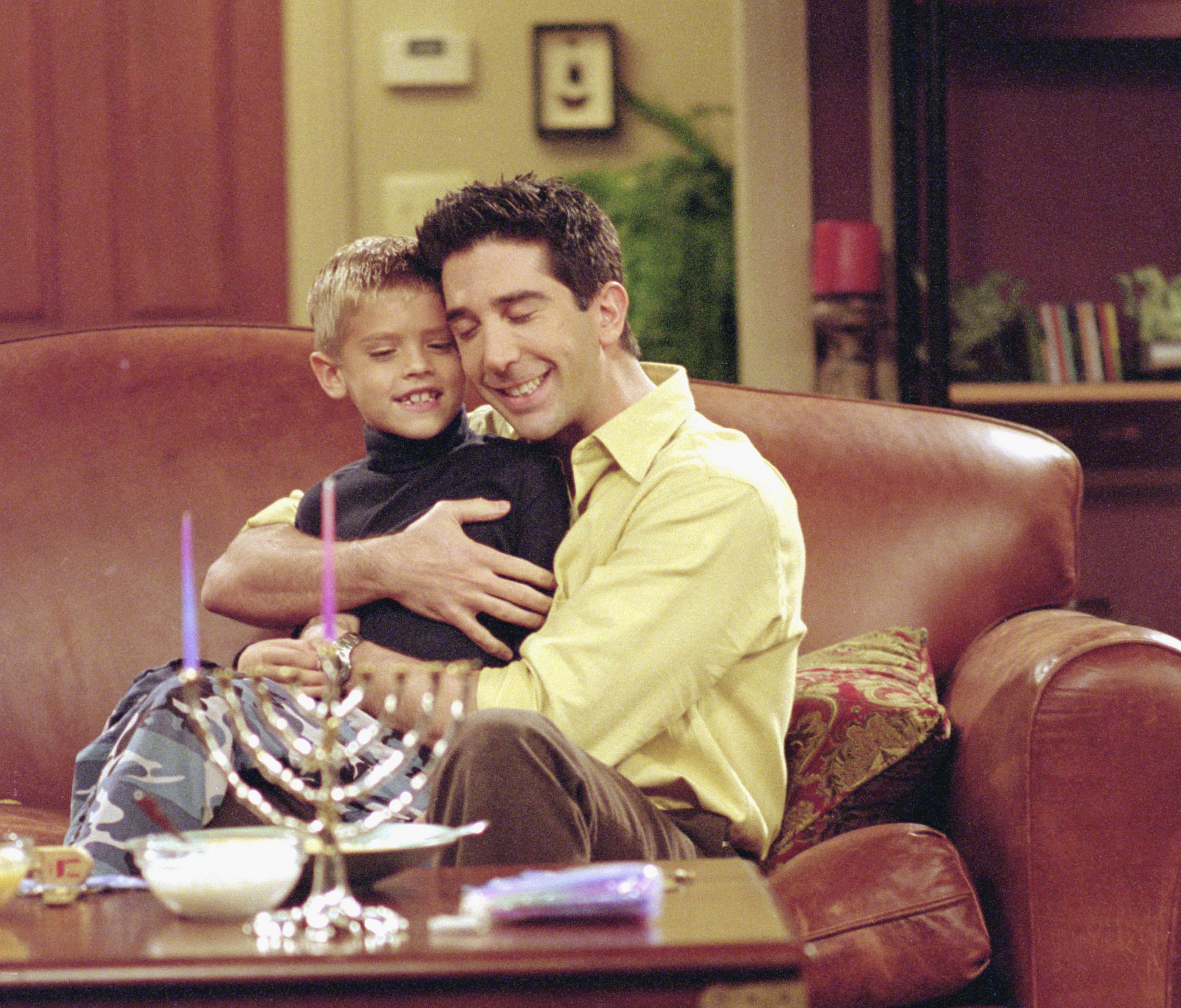 Cole Sprouse y David Schwimmer rodando una escena en "Friends" en 2000. | Fuente: Getty Images