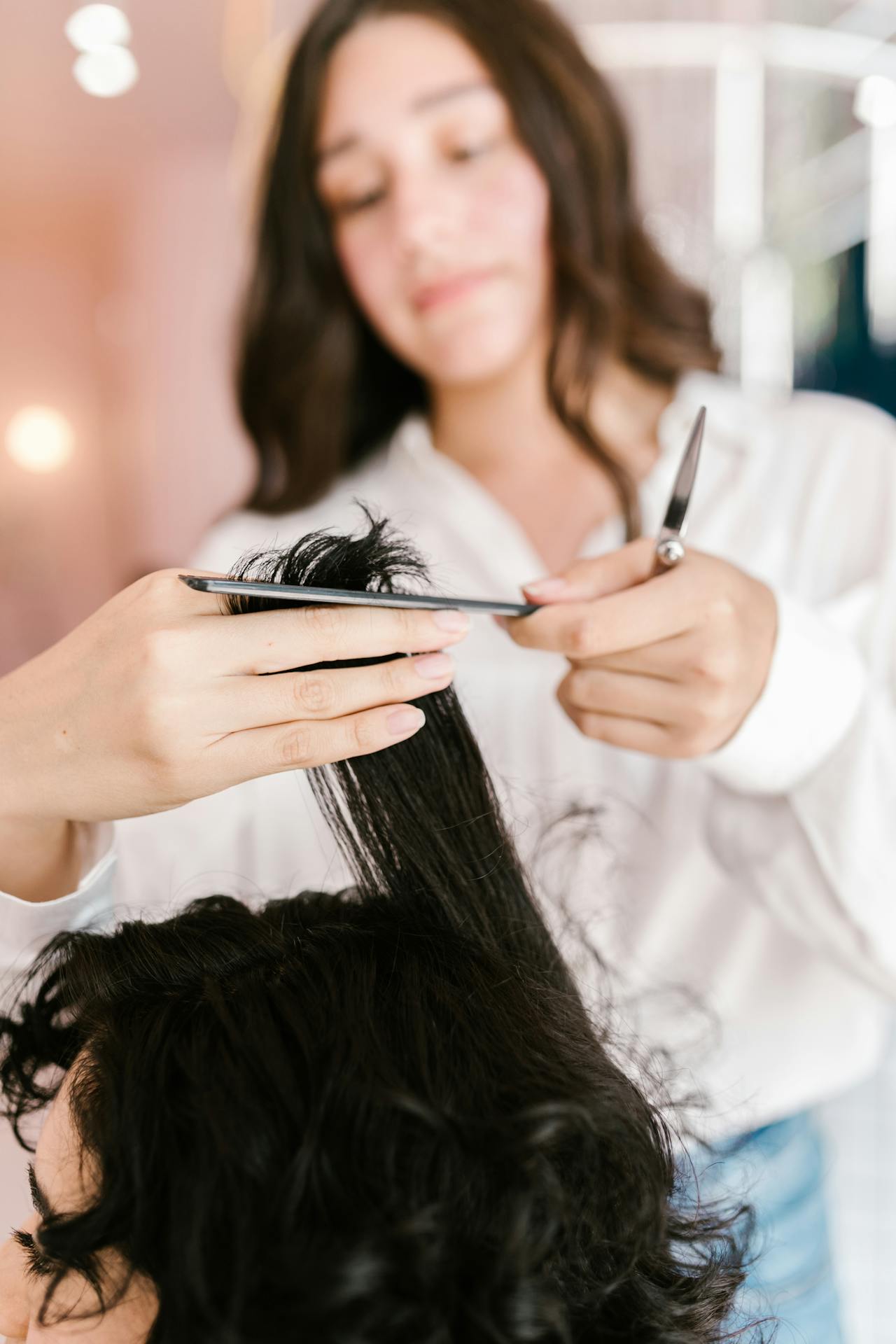 Un estilista cortando el pelo a una mujer en un salón | Fuente: Pexels