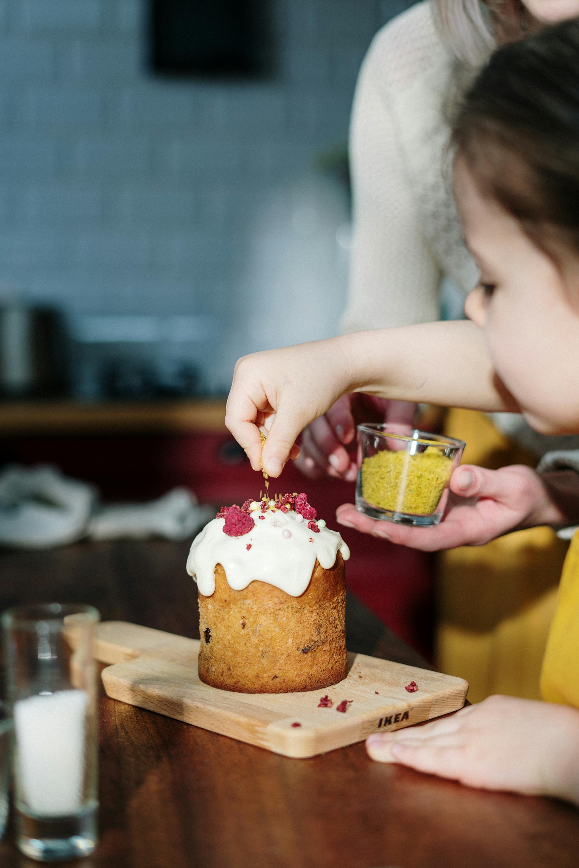 Niña decorando un pastel | Foto: Pexels