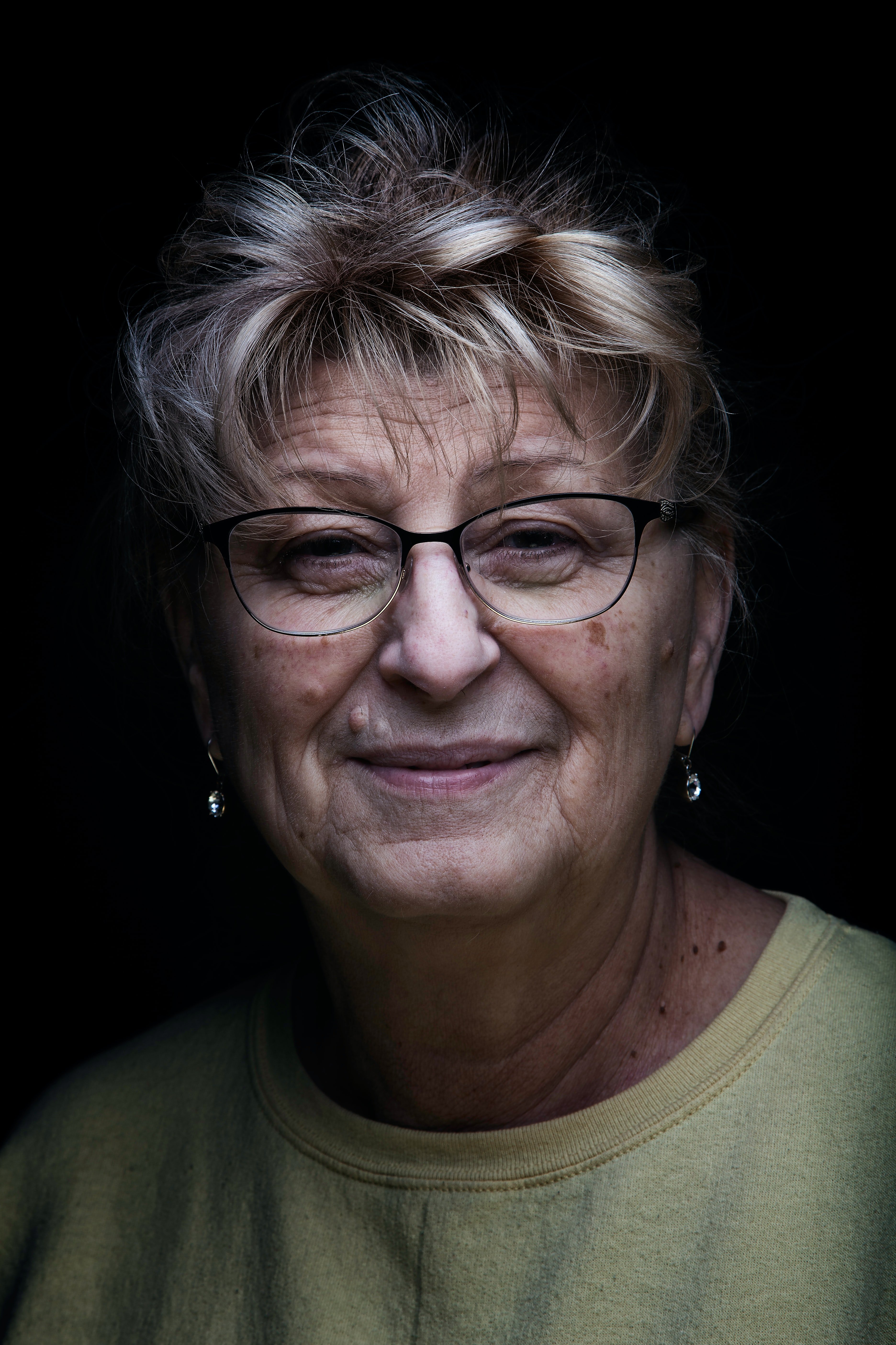 Una anciana con anteojos sonriendo. | Foto: Unsplash