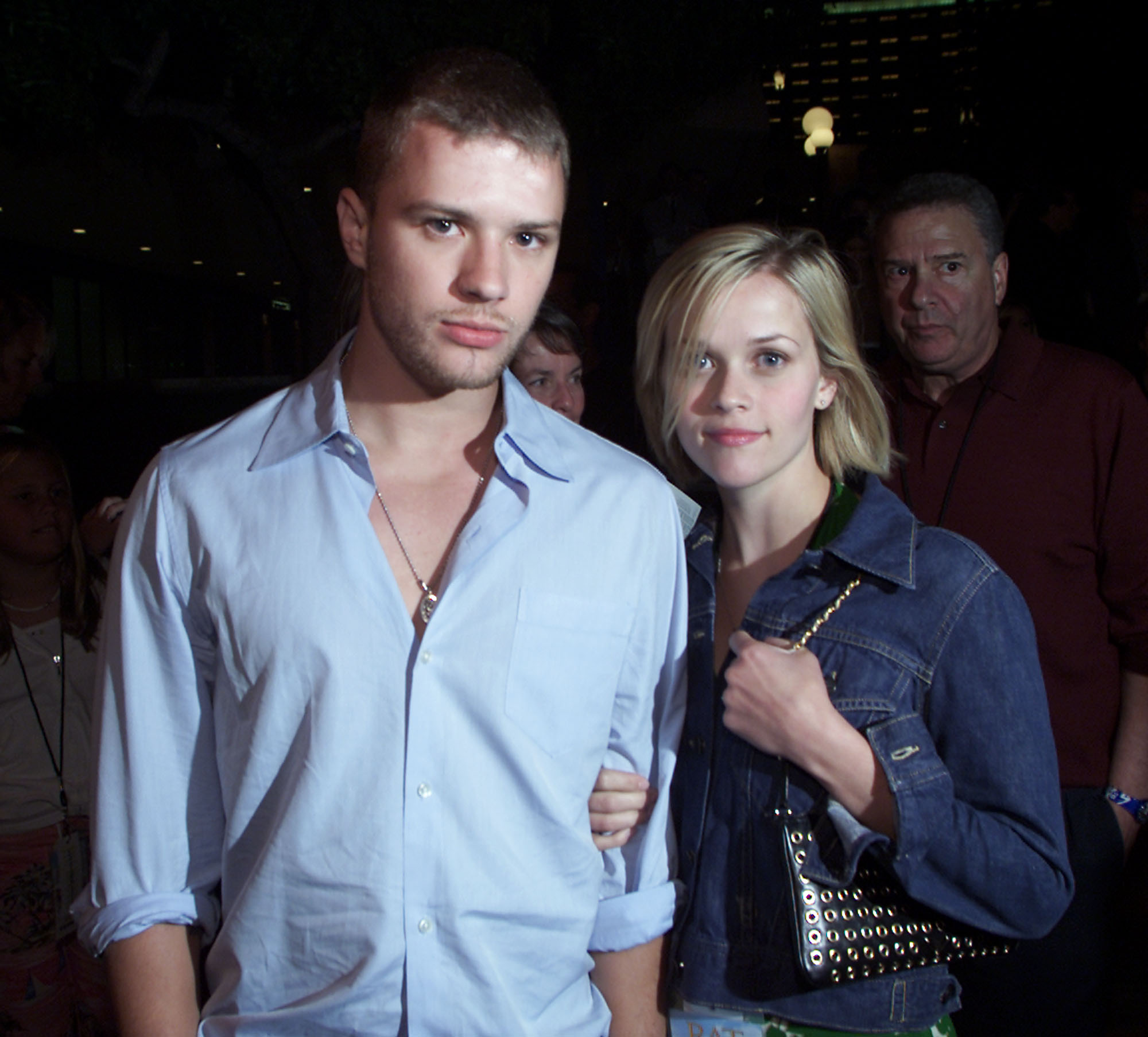Witherspoon y Phillippe asistieron al estreno de "Rat Race" en el Cineplex Odeon Century Plaza de Los Ángeles, California, el 30 de julio de 2001. Witherspoon apoya sus manos sobre los brazos de Phillippe mientras posan muy juntos, ambos mirando directamente a la cámara.