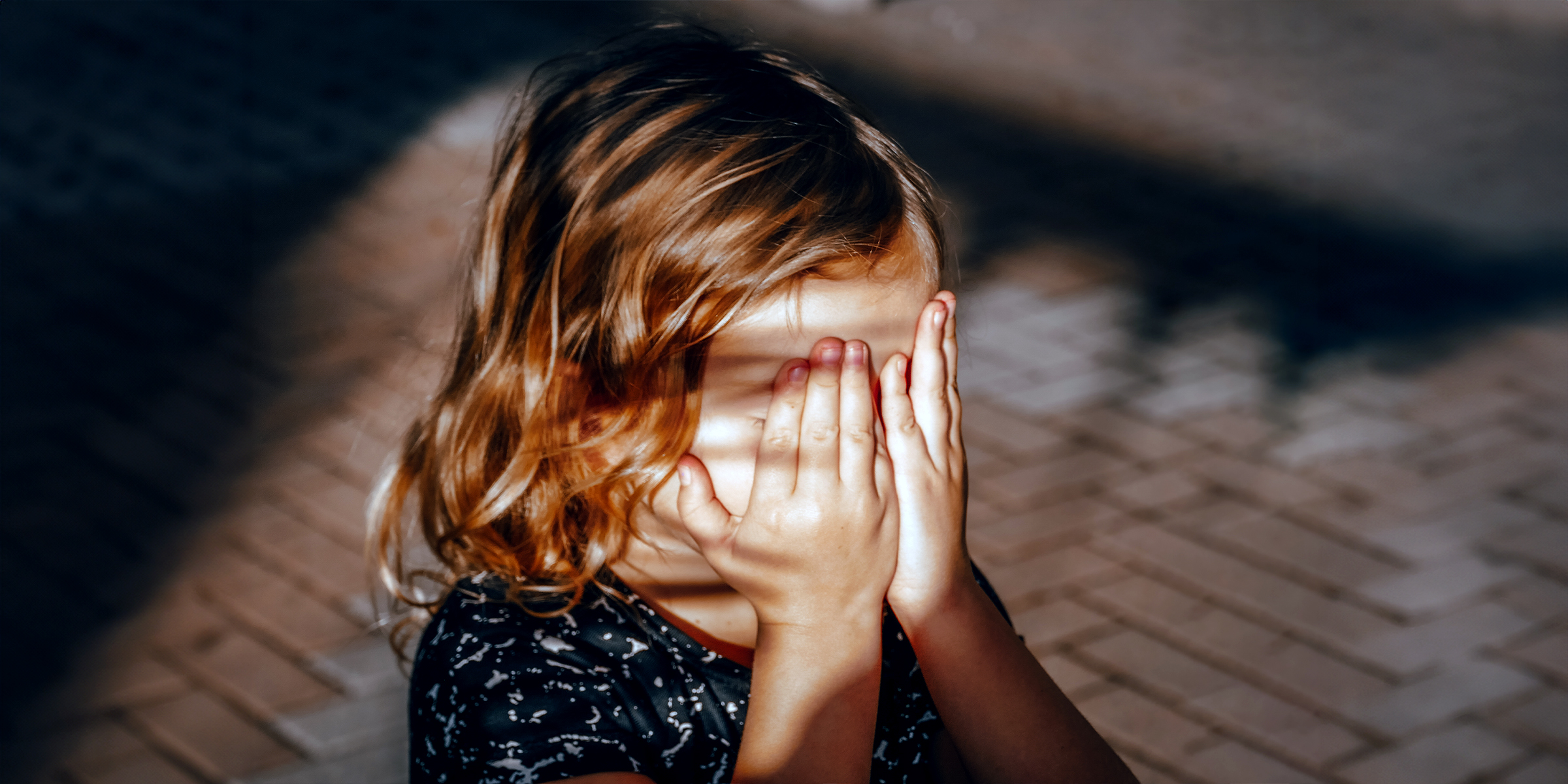 Niña oculta su rostro con las manos | Foto: Shutterstock