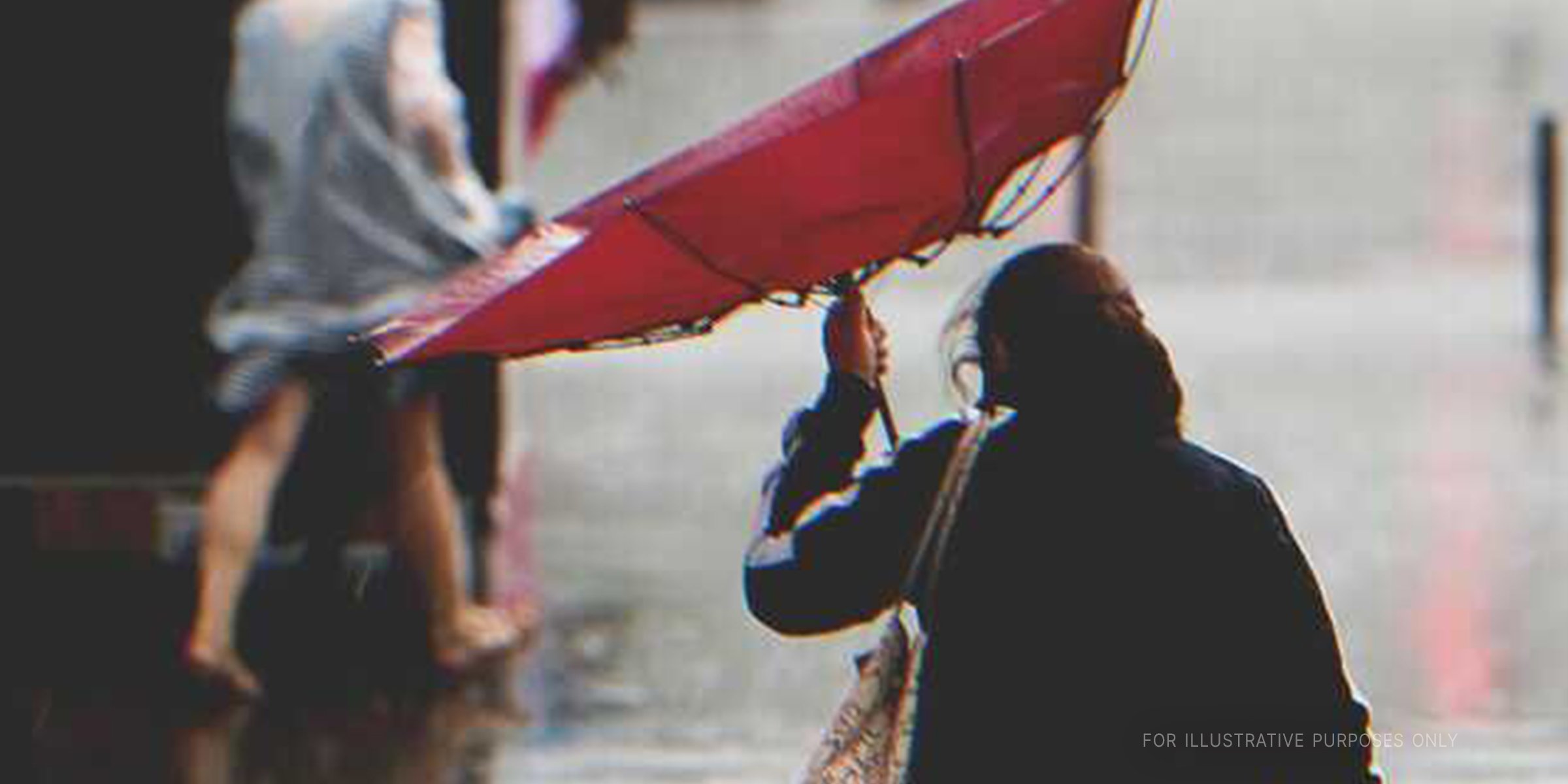 Mujer caminando bajo la lluvia con un paraguas. | Foto: Shutterstock