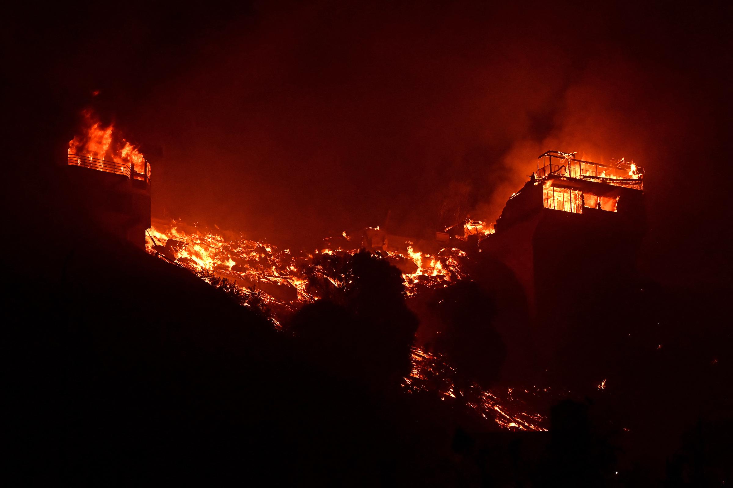 Arden estructuras a lo largo de la Autopista de la Costa del Pacífico durante el incendio Palisades en Malibú, California, el 8 de enero de 2025 | Fuente: Getty Images