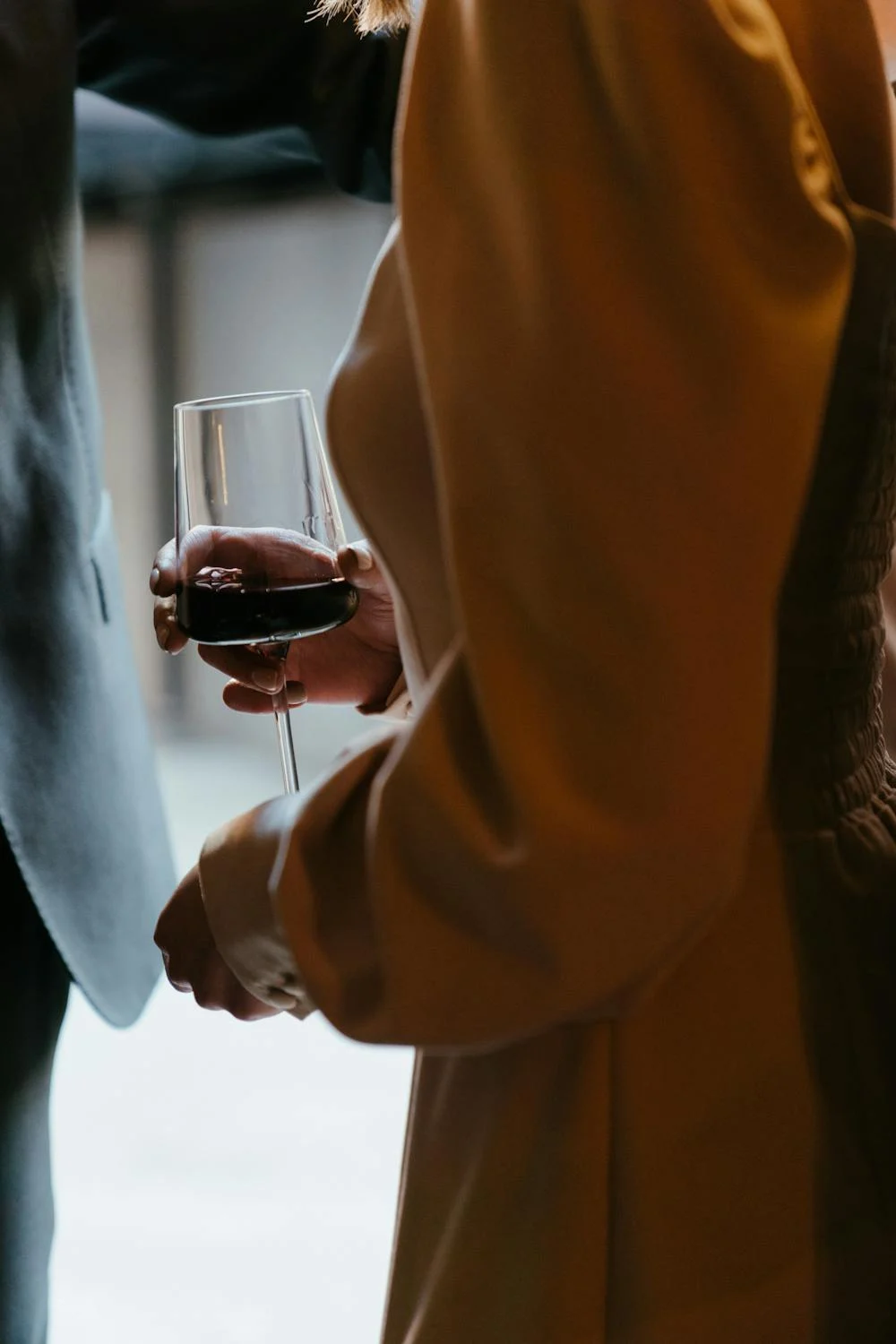 Una mujer con un vaso de vino tinto en la mano | Fuente: Pexels