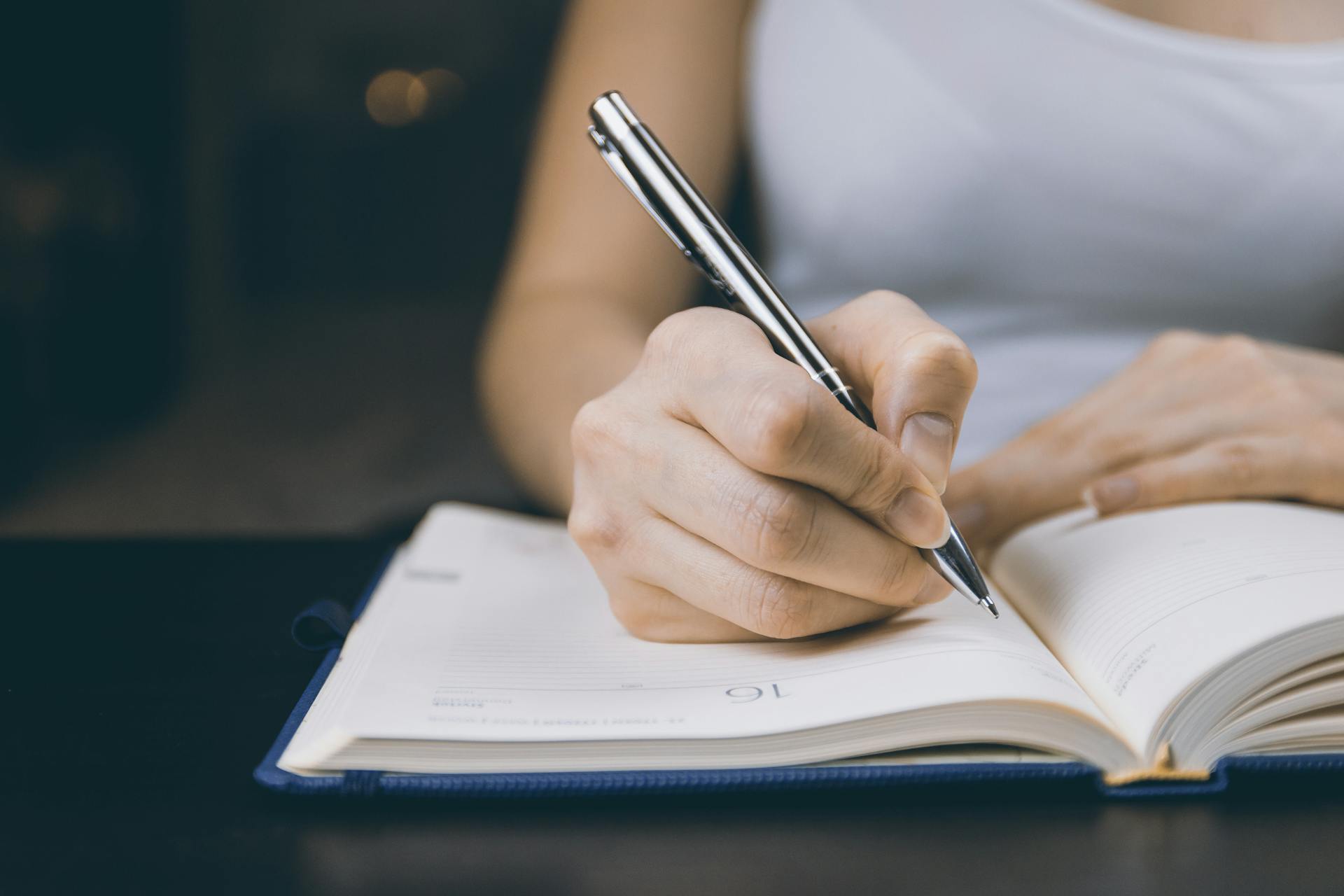 Una mujer escribiendo en un cuaderno | Fuente: Pexels