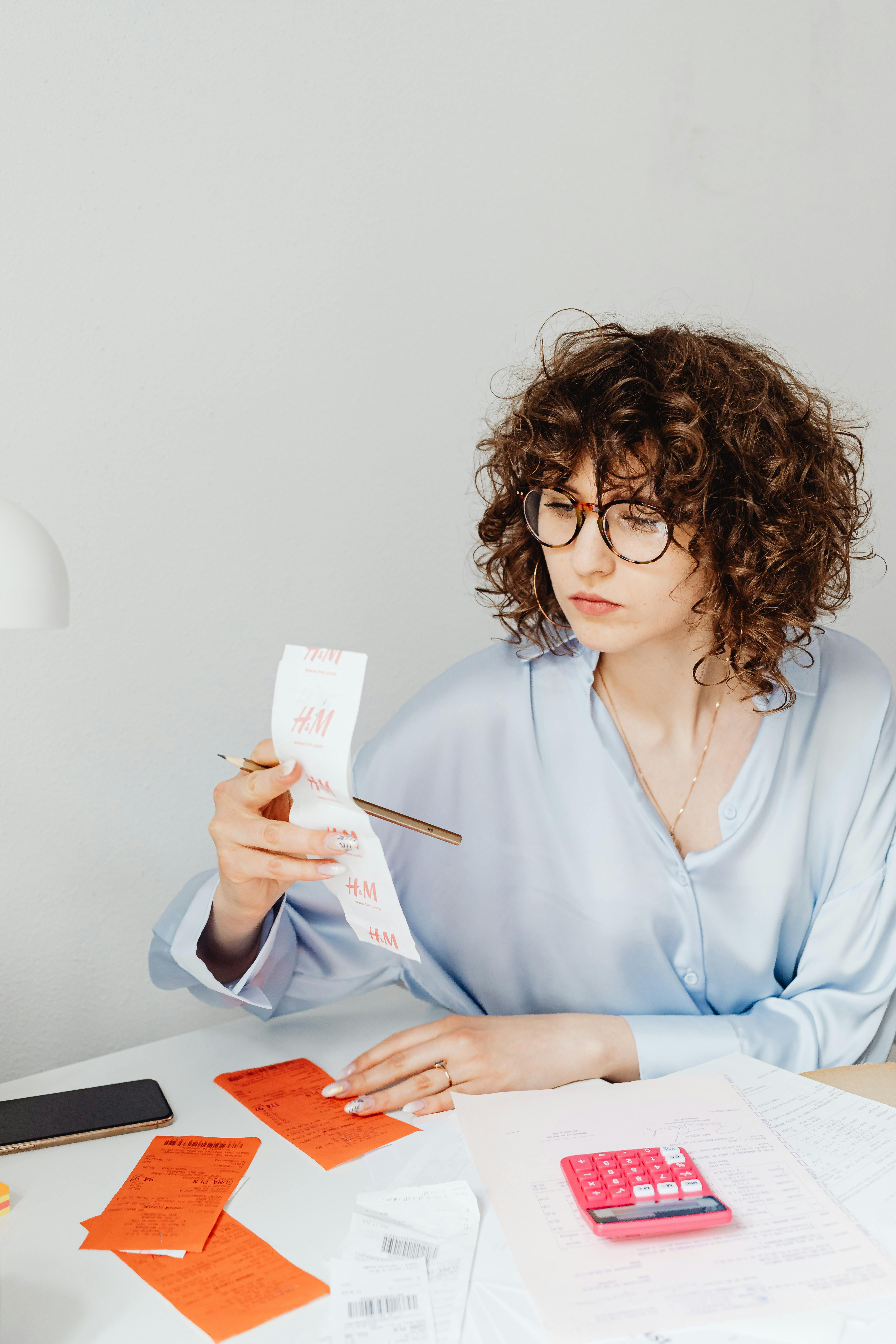 Una mujer preocupada mirando los recibos | Fuente: Pexels