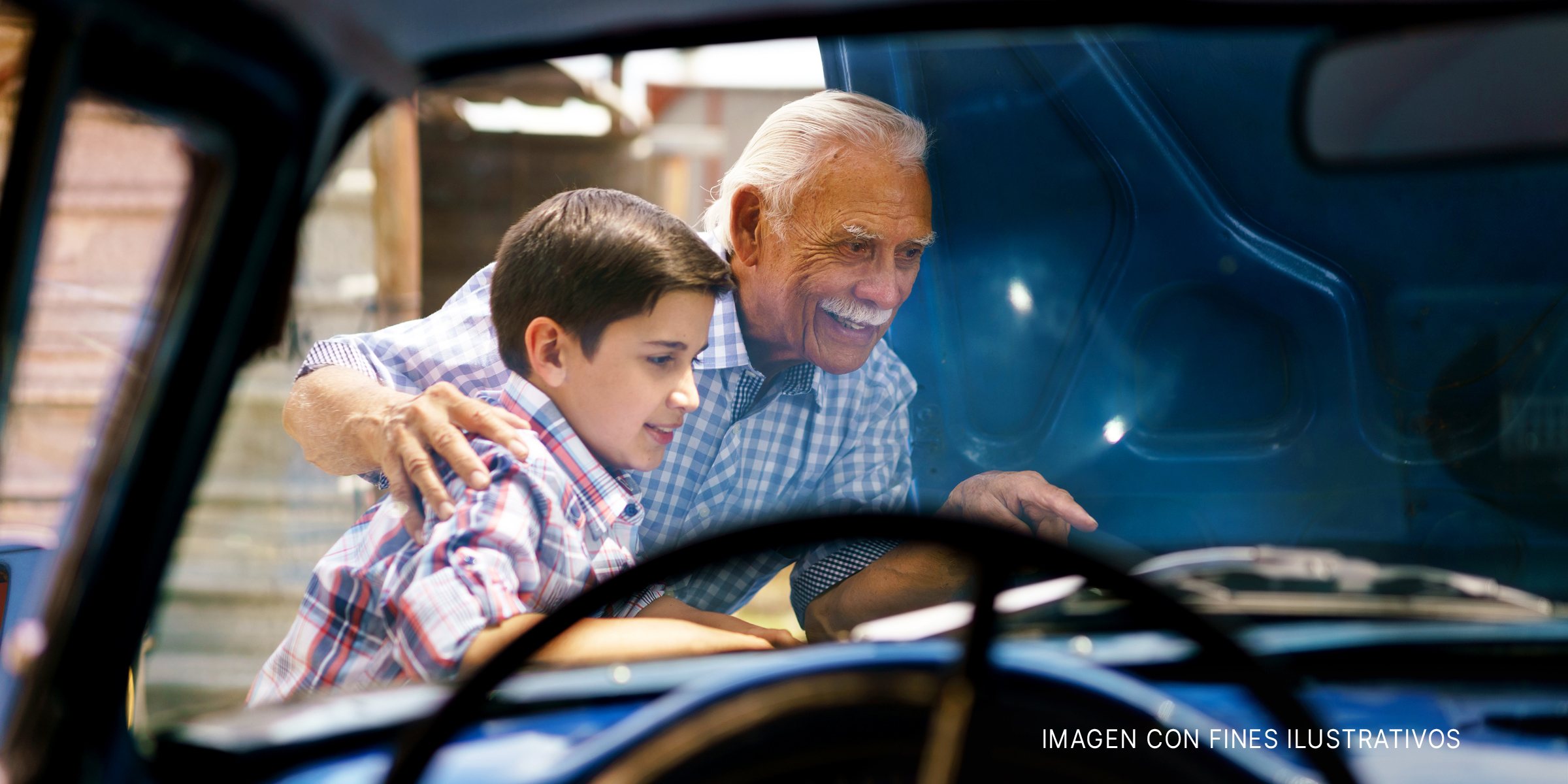 Abuelo y nieto trabajando en un automóvil | Foto: Shutterstock