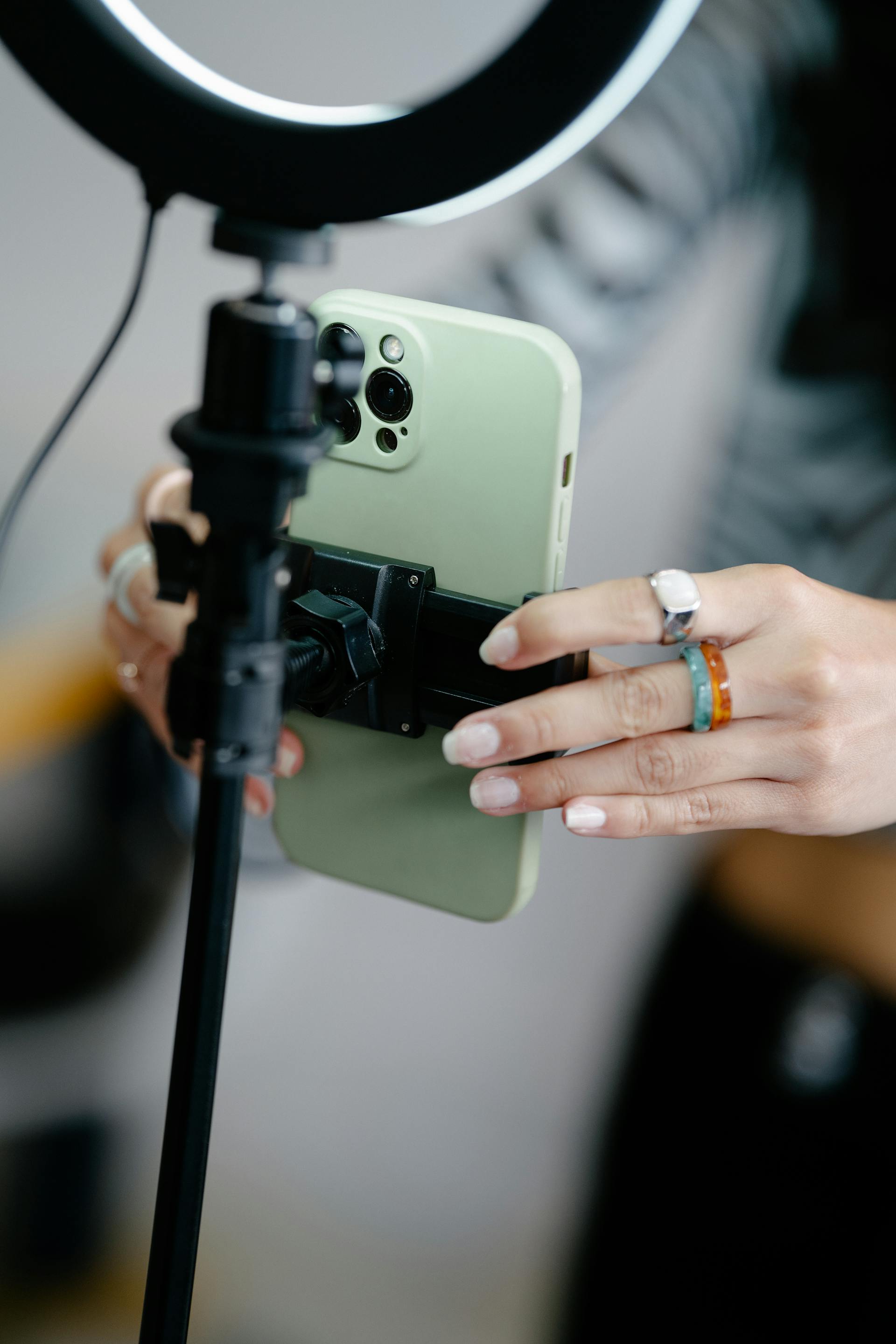 Una mujer arreglando un teléfono en un trípode | Fuente: Pexels