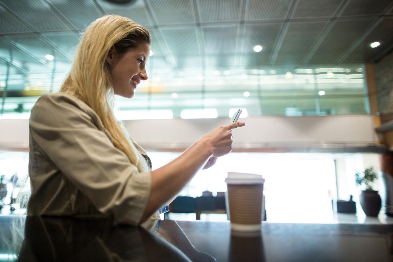 Una mujer hablando por teléfono en un aeropuerto | Fuente: Freepik