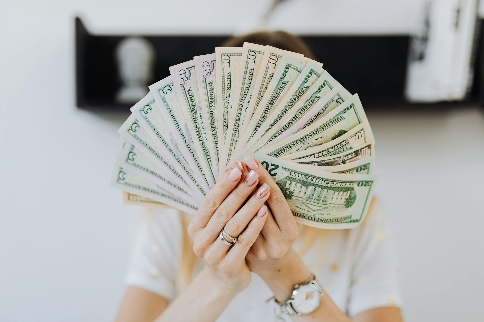 Una mujer con dinero en la mano | Fuente: Pexels