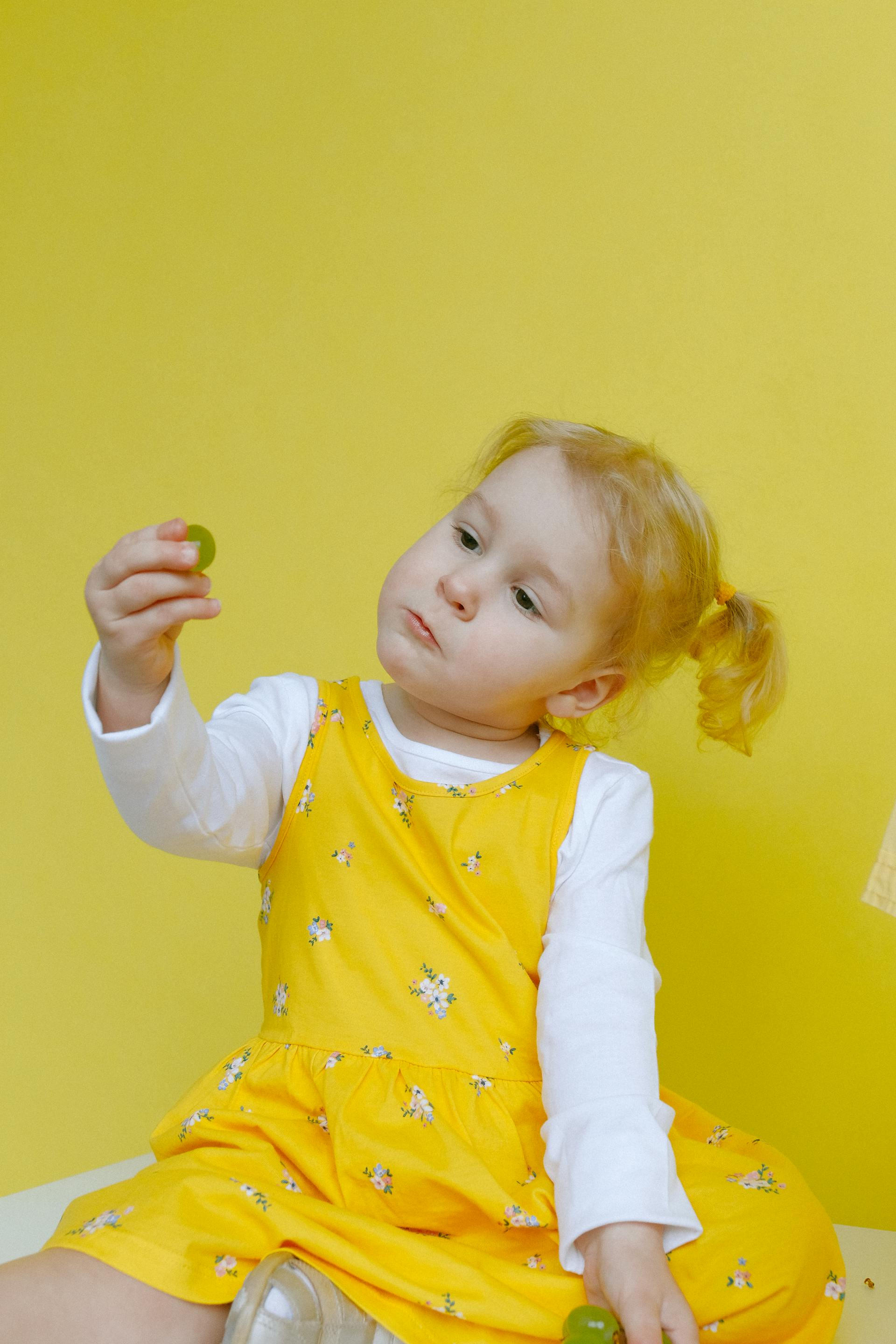 Una niña mirando una pelota en la mano | Fuente: Pexels