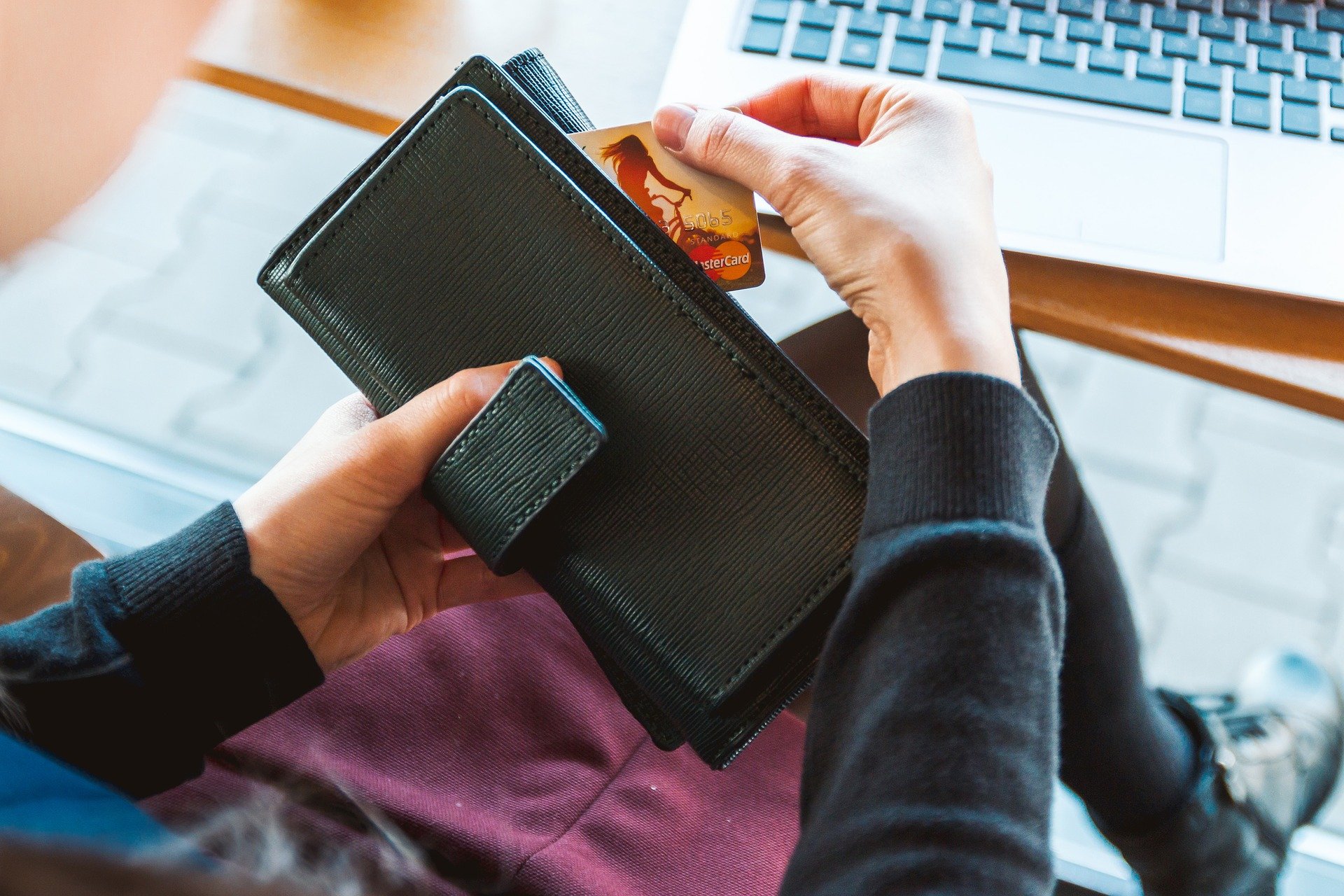 Mujer saca tarjeta bancaria de cartera. | Foto: Pixabay